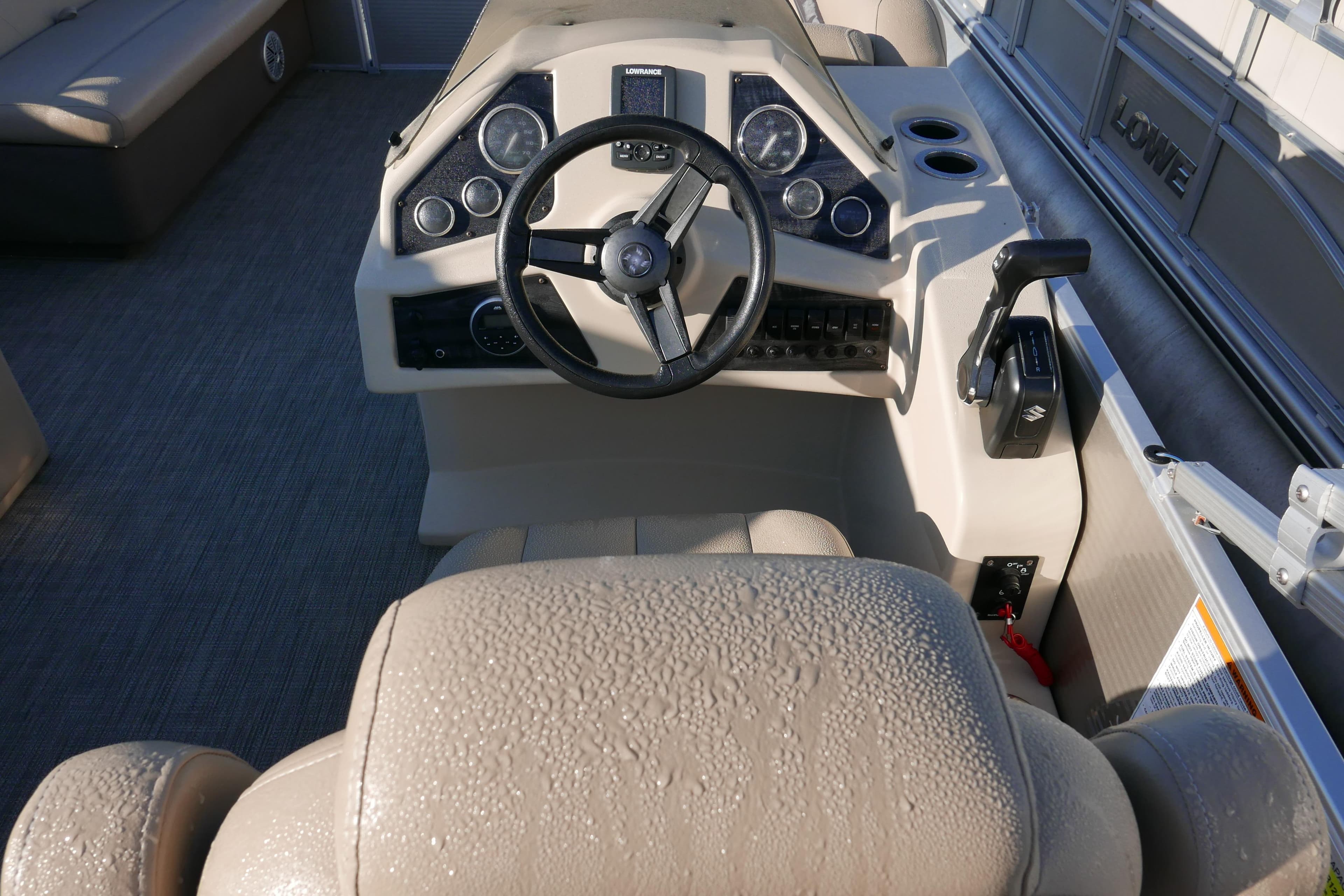 Steering console of 2018 Sweetwater SW2086c boat with control panel and seating.