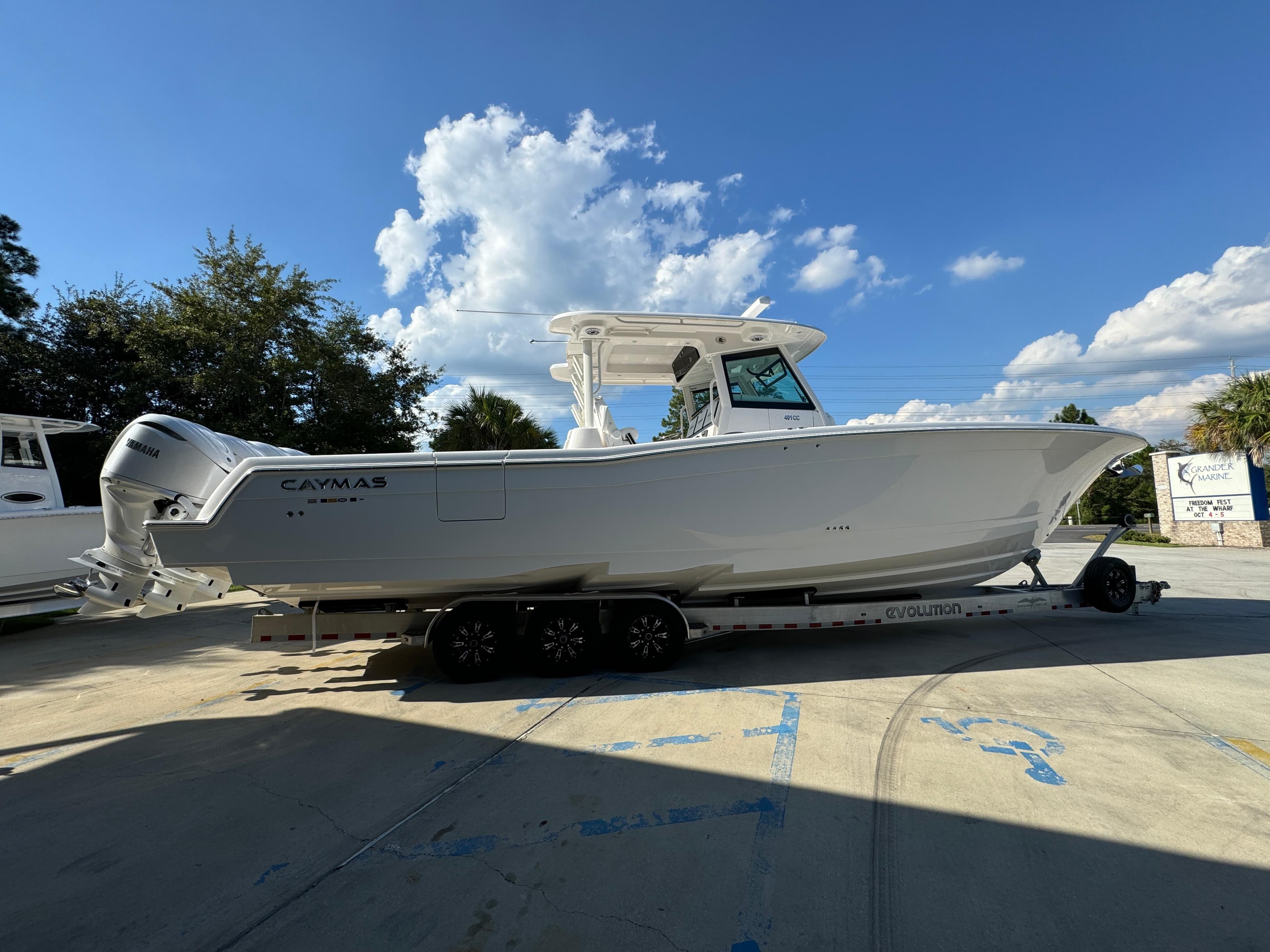 2025 Caymas 401 CC boat on trailer under a clear blue sky.