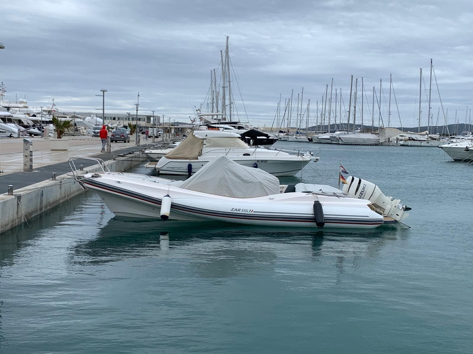 A 2020 Zar 85 SL boat docked in a marina with overcast skies.