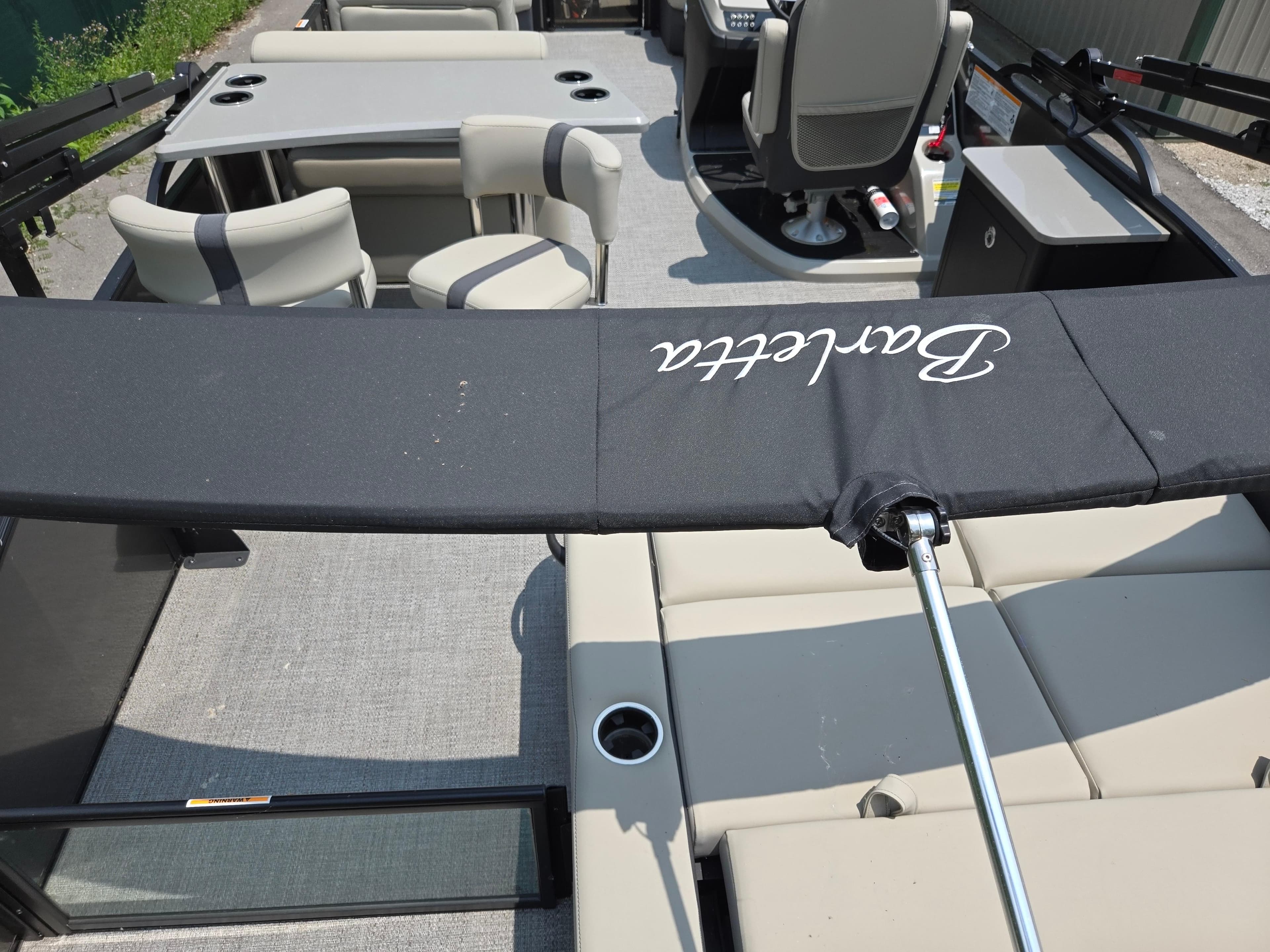 2023 Barletta Cabrio 24UE pontoon boat interior with seating and table setup.