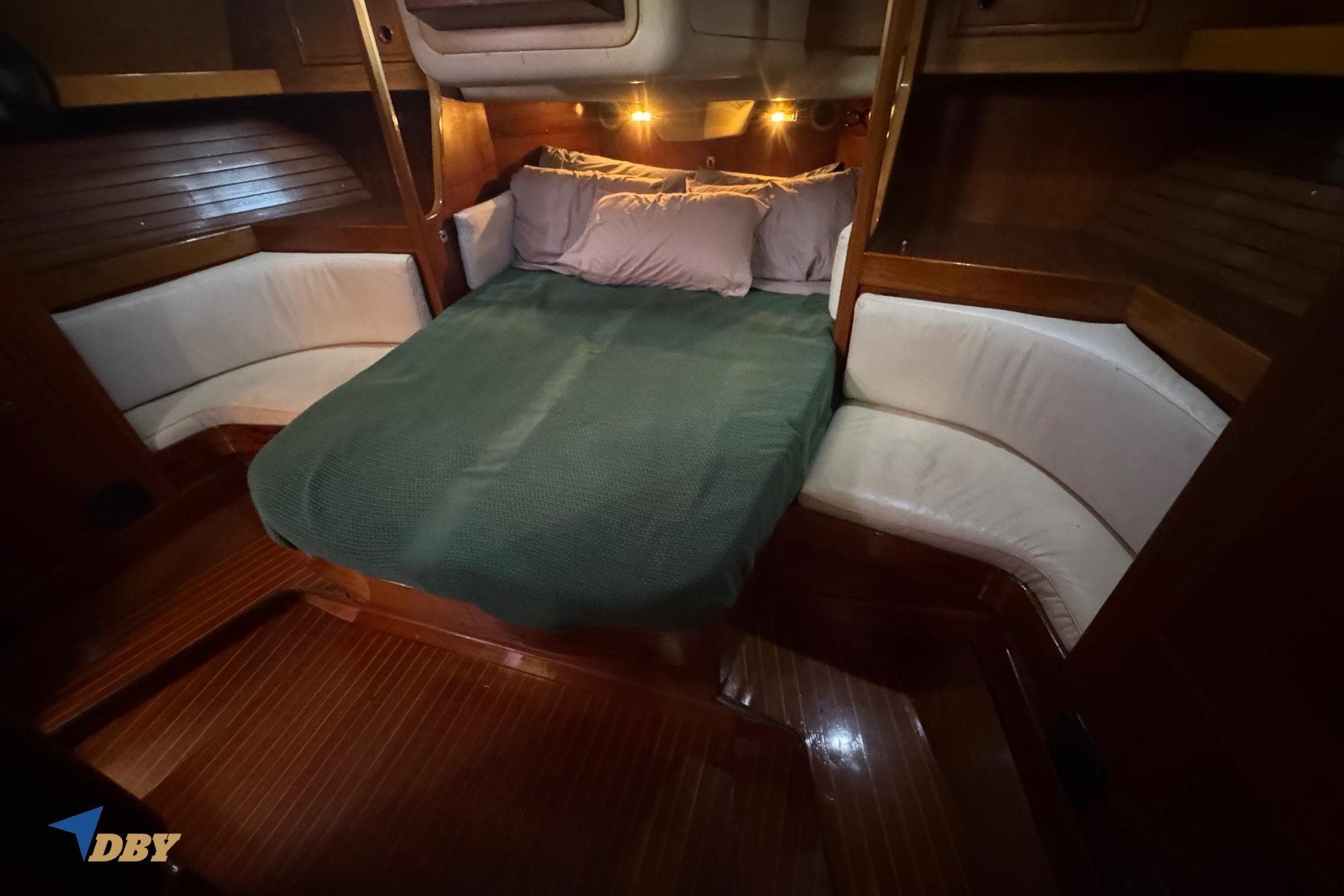 Cozy cabin interior of 1981 Baltic 42 sailboat with wooden finish and comfortable bedding.