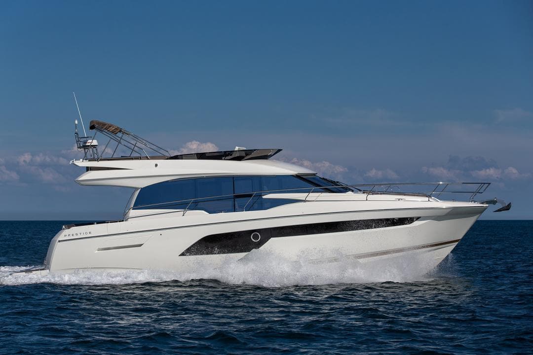 2024 Prestige 520 Flybridge yacht cruising on open water under clear skies.