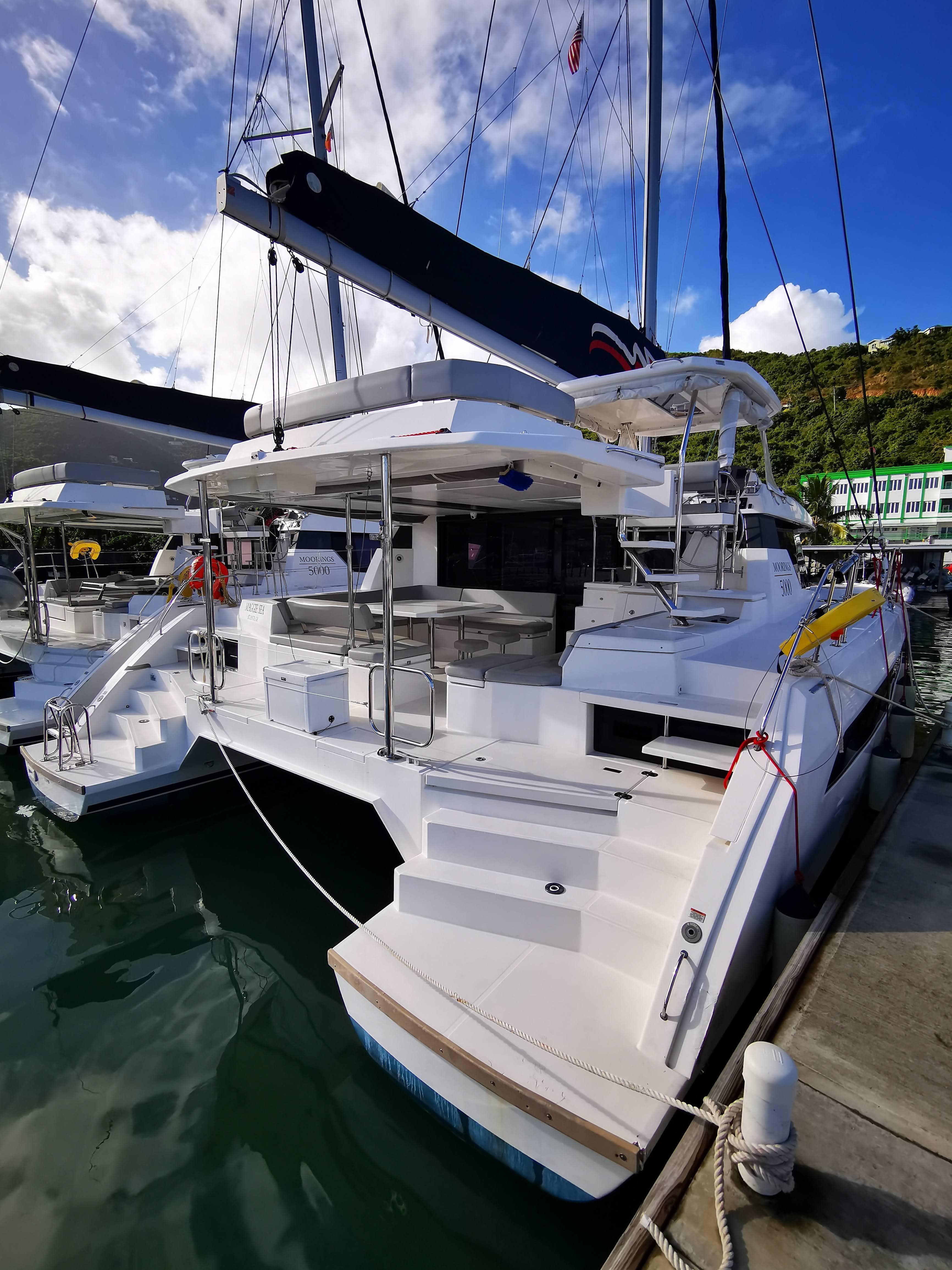 Leopard 50 catamaran, 2021 model, docked at marina under clear blue sky.