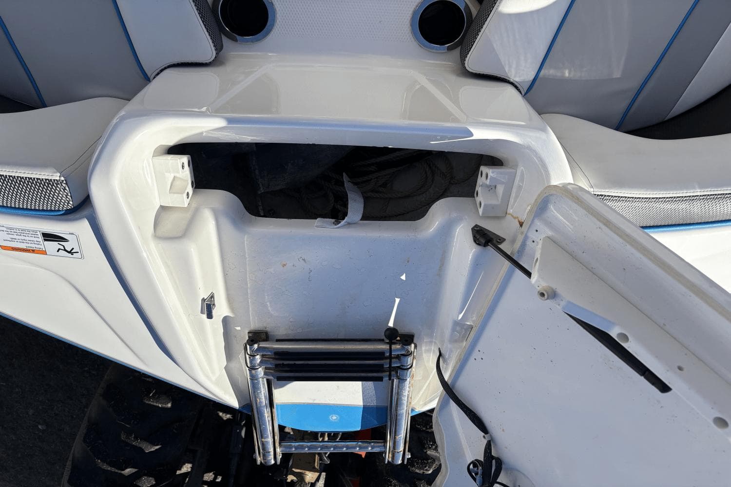 Open storage compartment on a 2021 Yamaha Boats 212XE, featuring a foldable ladder.