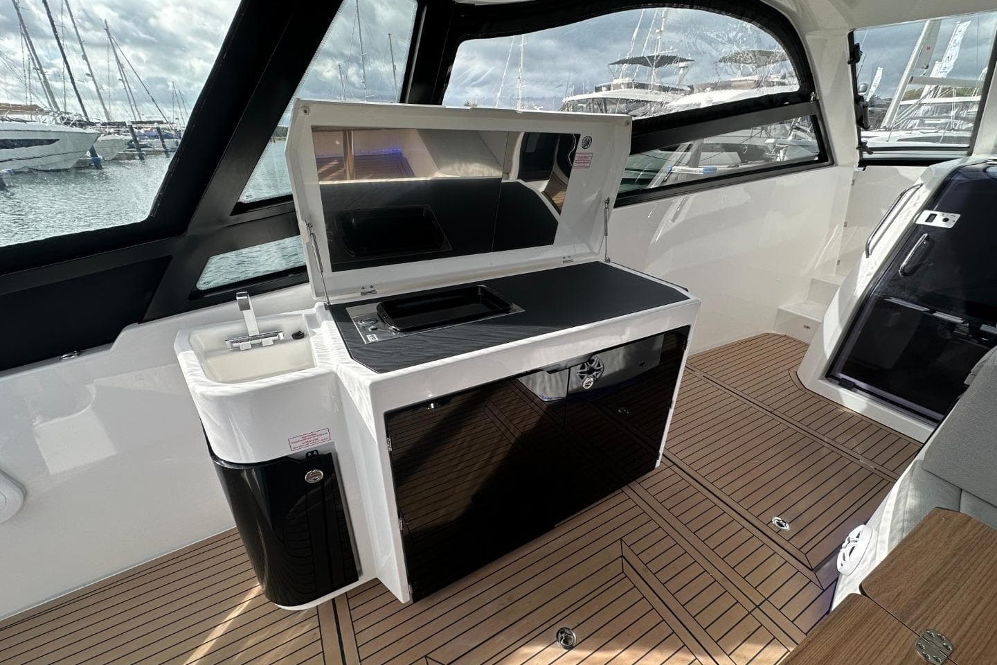 2026 Bavaria Vida 33 yacht interior with kitchenette and wooden flooring.