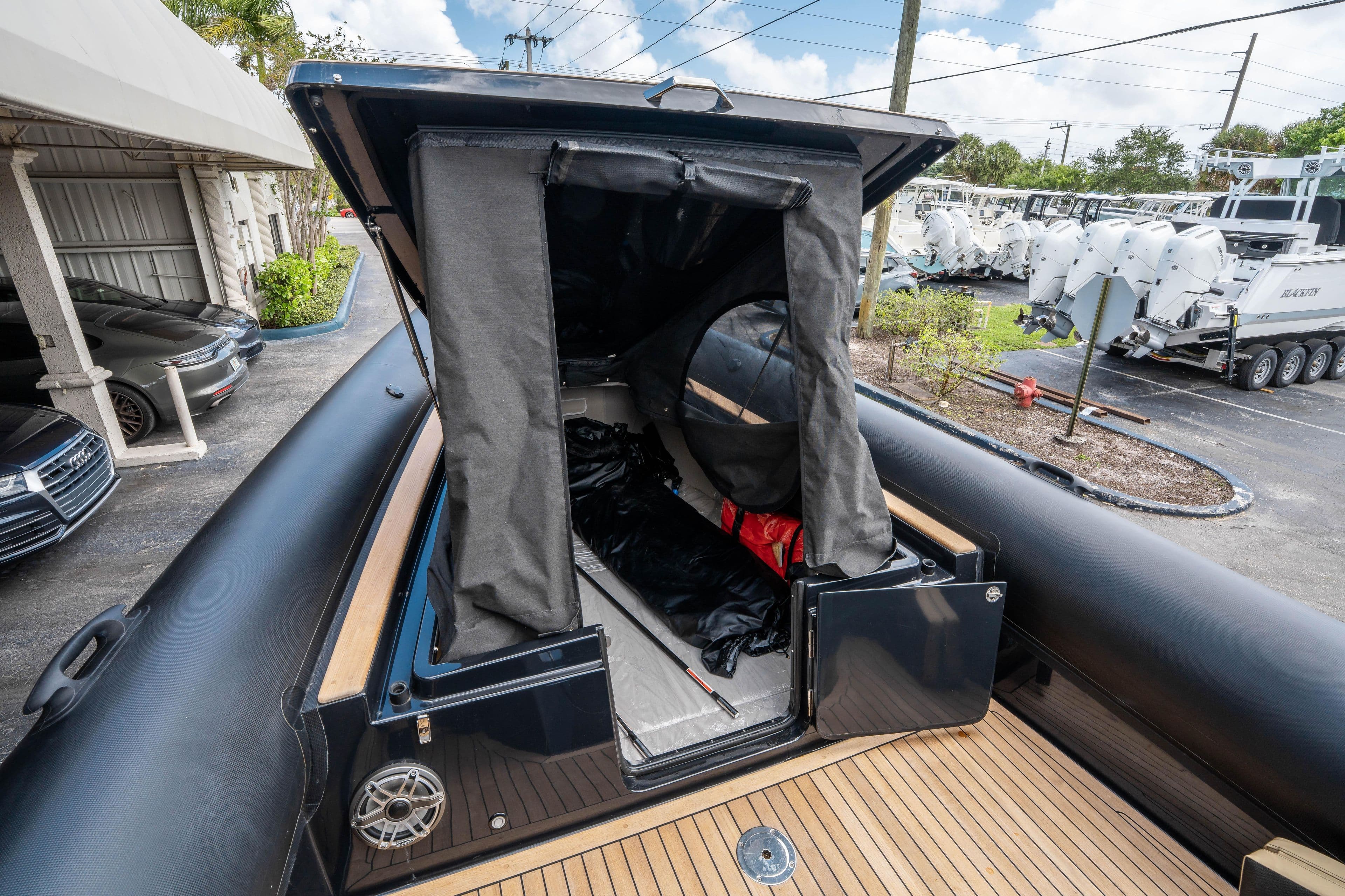2023 Ribco Seafarer 36 X boat with open storage compartment, docked outdoors.
