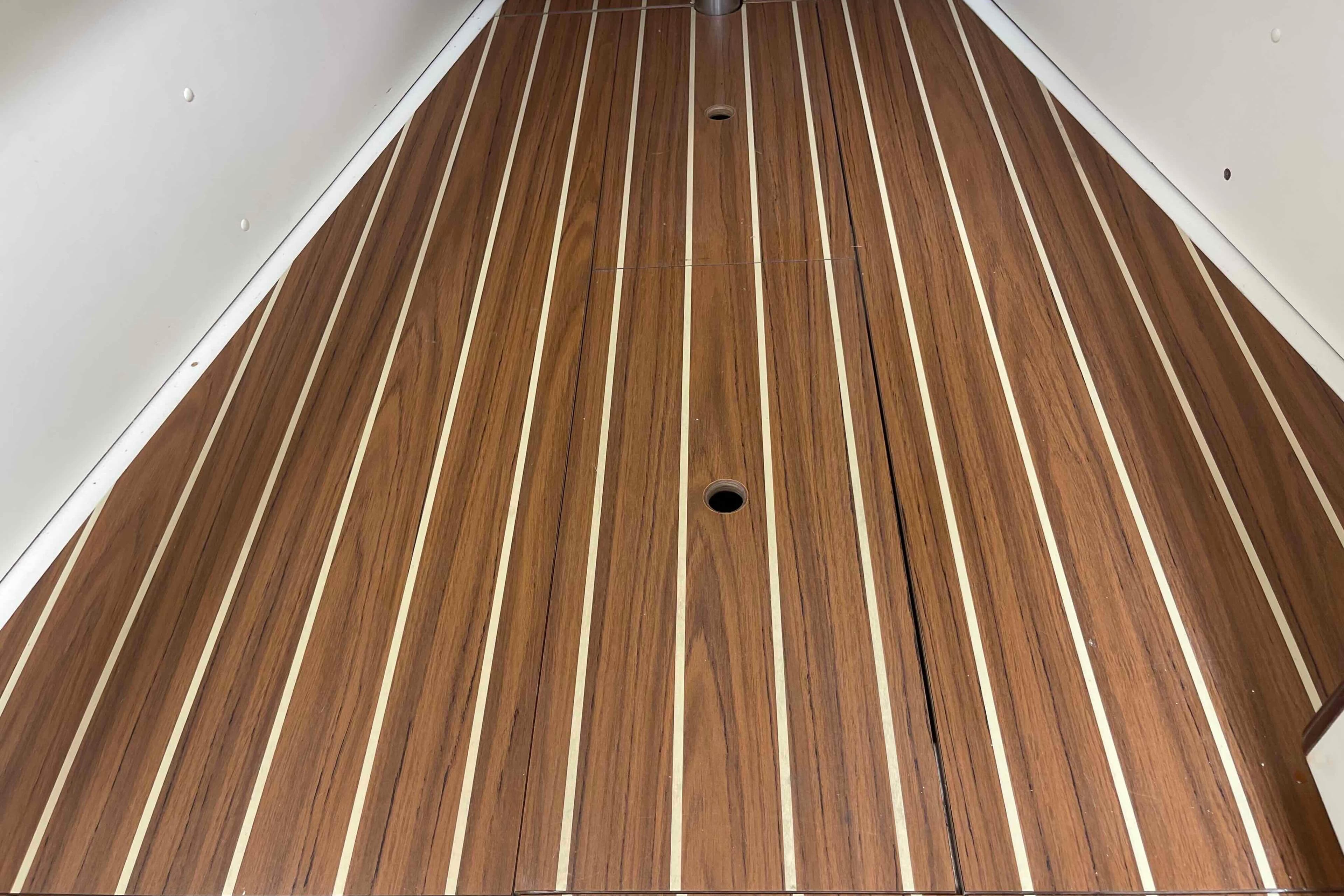 Teak flooring inside a 2006 Hunter 270 sailboat, showcasing elegant wood grain and craftsmanship.