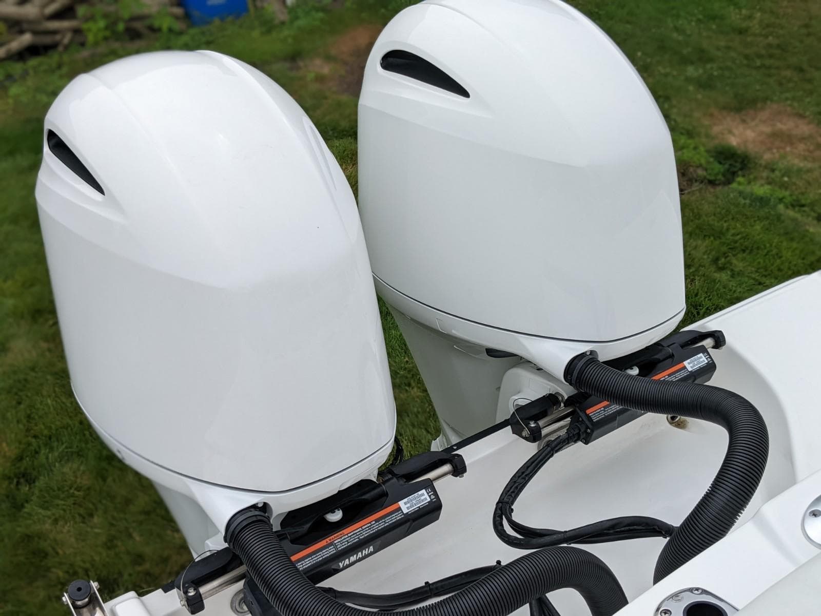 Twin outboard motors on a 2021 Edgewater 262 CC boat, showcasing sleek design and power.