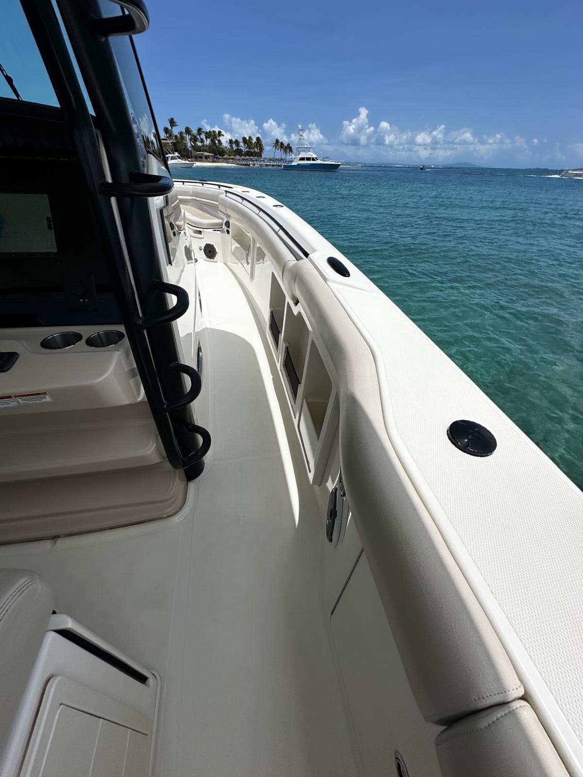 2020 Boston Whaler 380 Outrage on clear blue water, sunny day, palm trees in background.