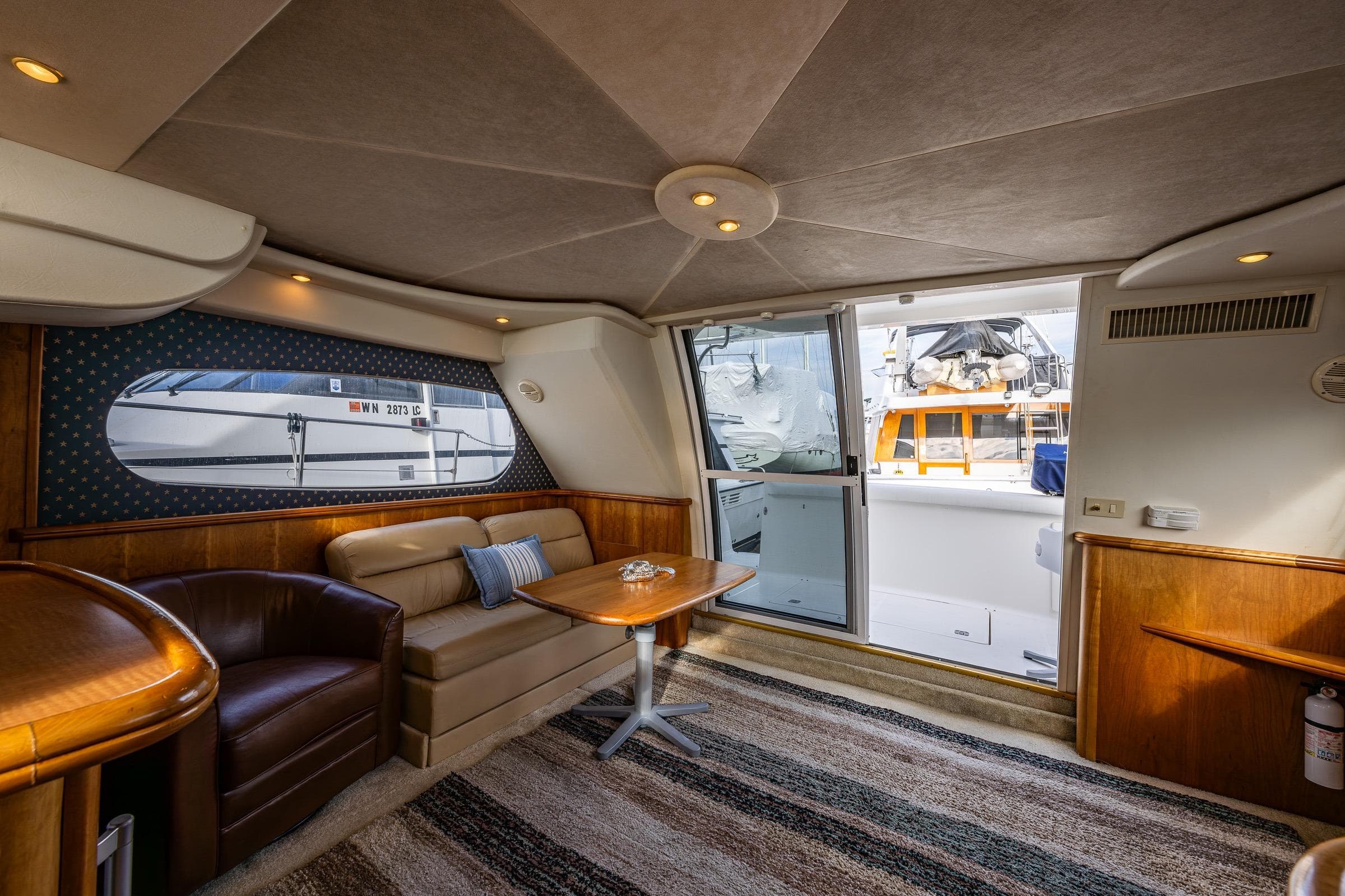 Interior of 2001 Silverton 410 Sport Bridge yacht with cozy seating and table.