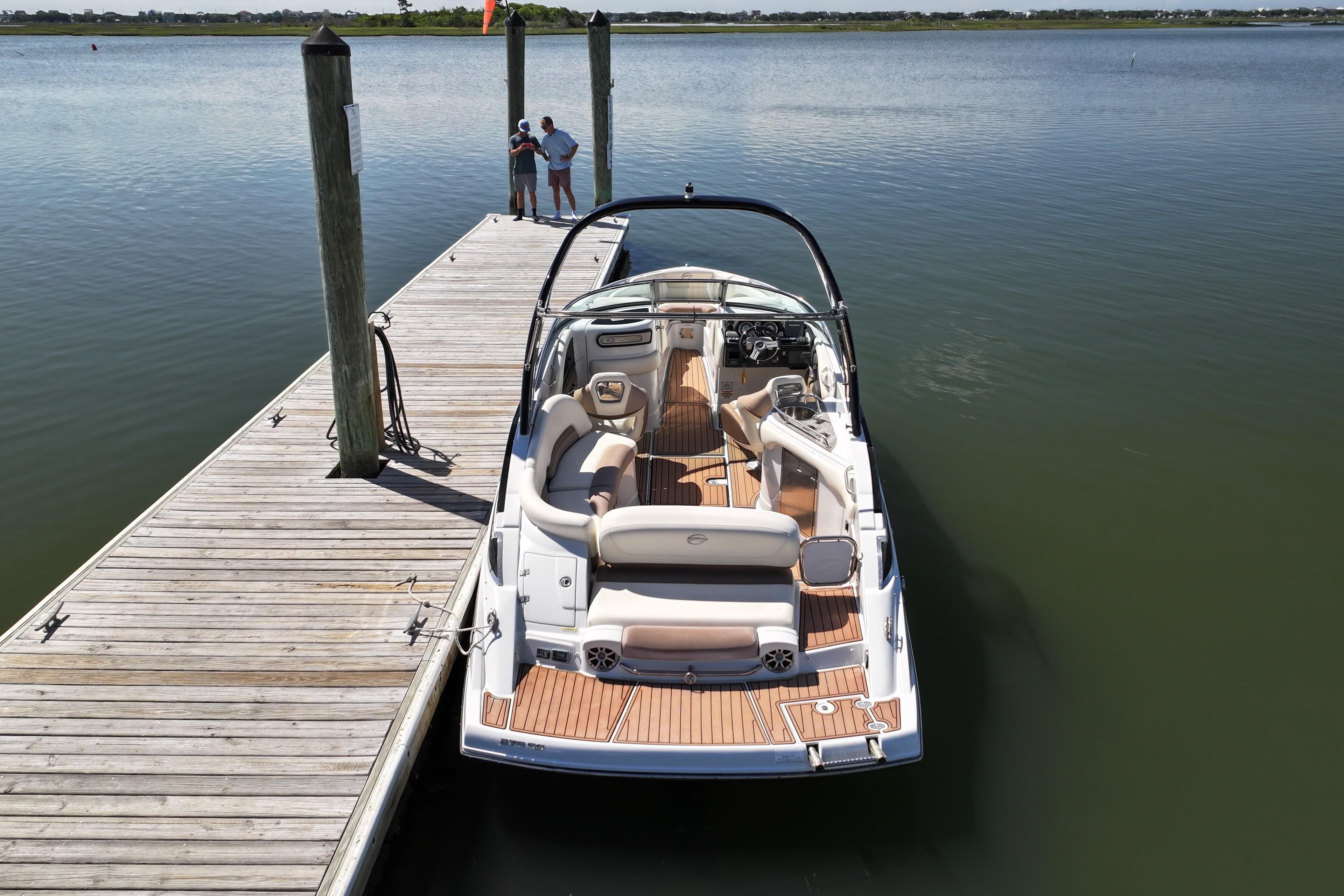 2017 Crownline 275 SS boat docked on calm water, featuring spacious seating and sleek design.