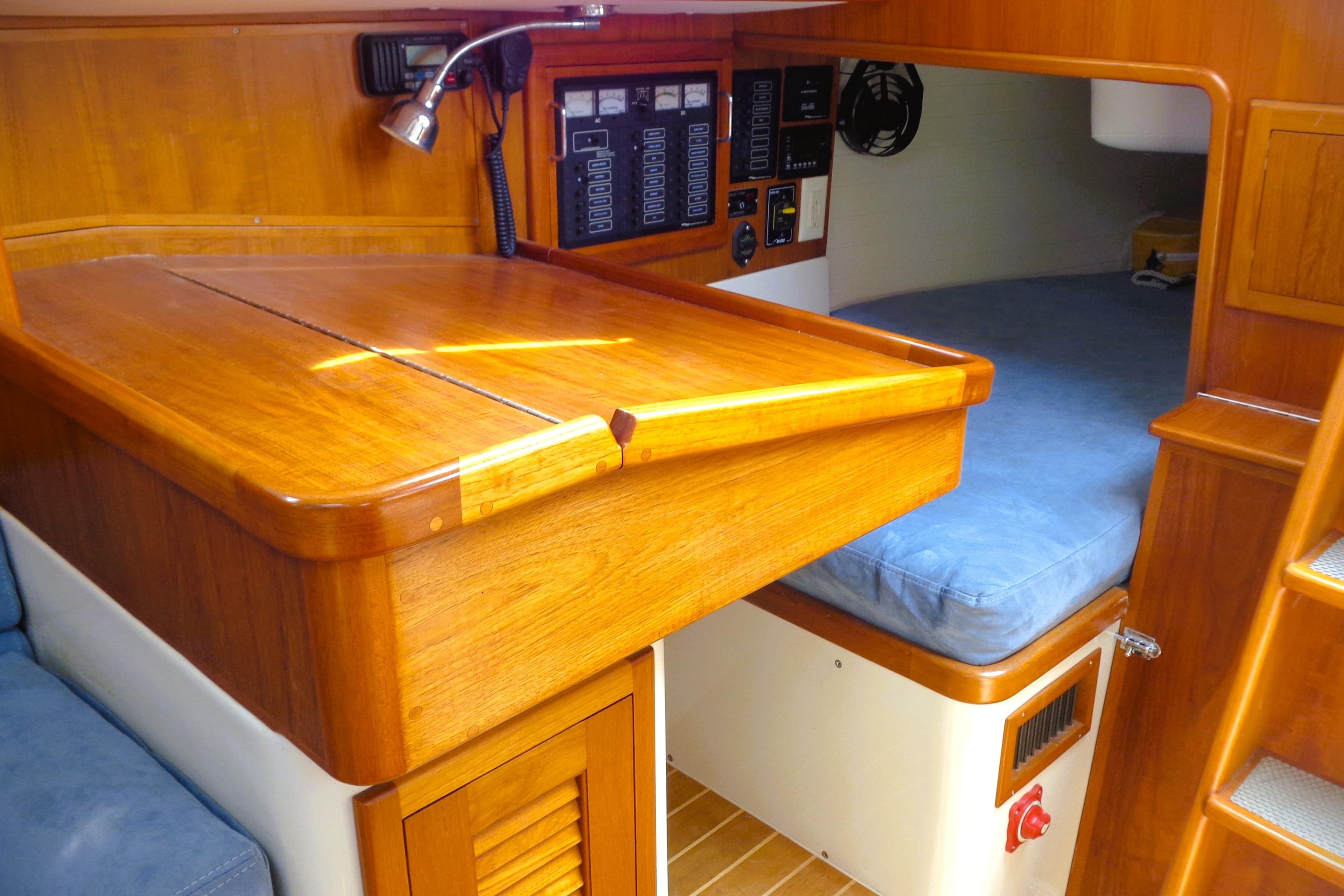 Interior of 2009 Pacific Seacraft 34 sailboat with wooden cabinetry and cozy sleeping area.