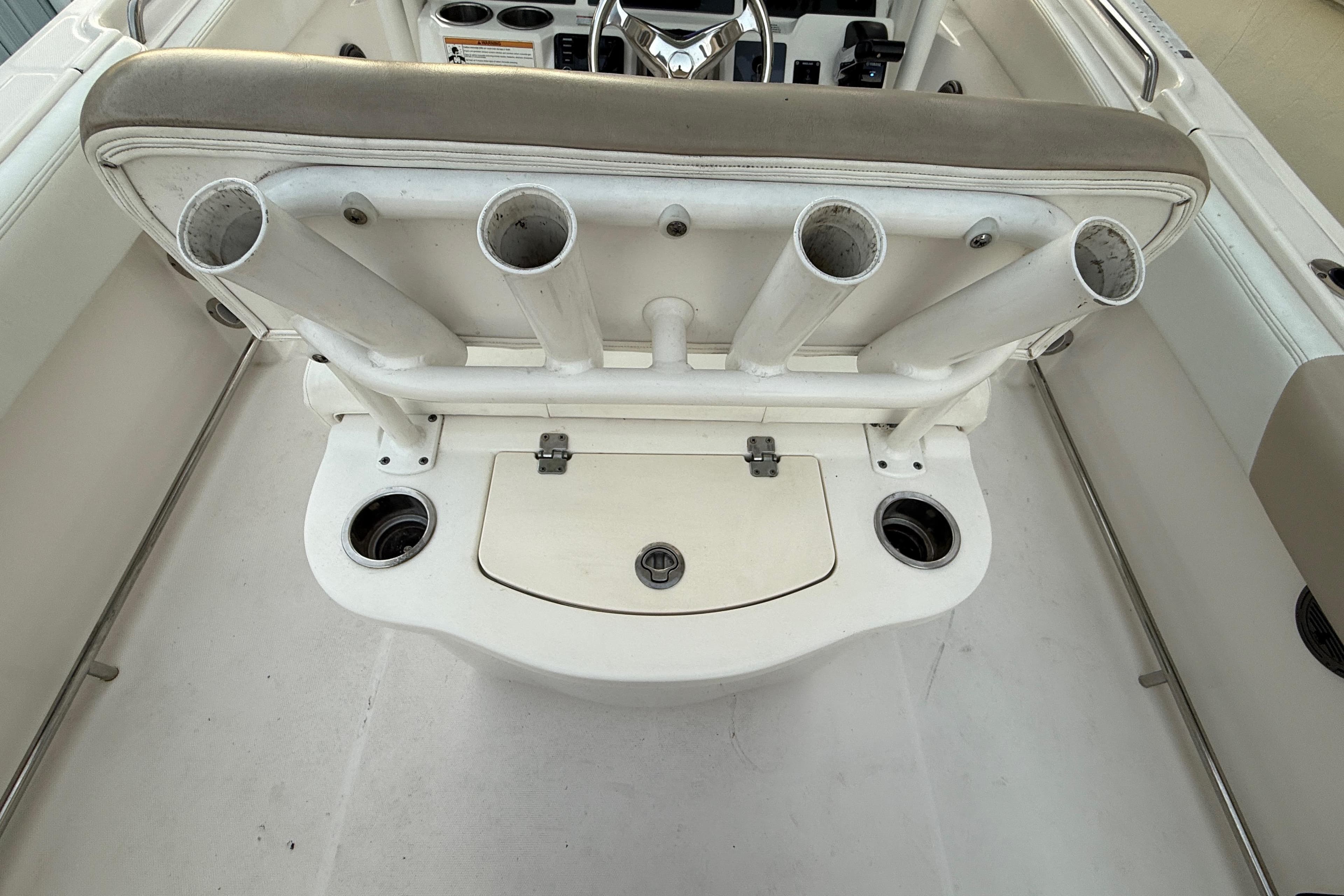 2018 Robalo R242 Center Console boat with rod holders and storage compartment.