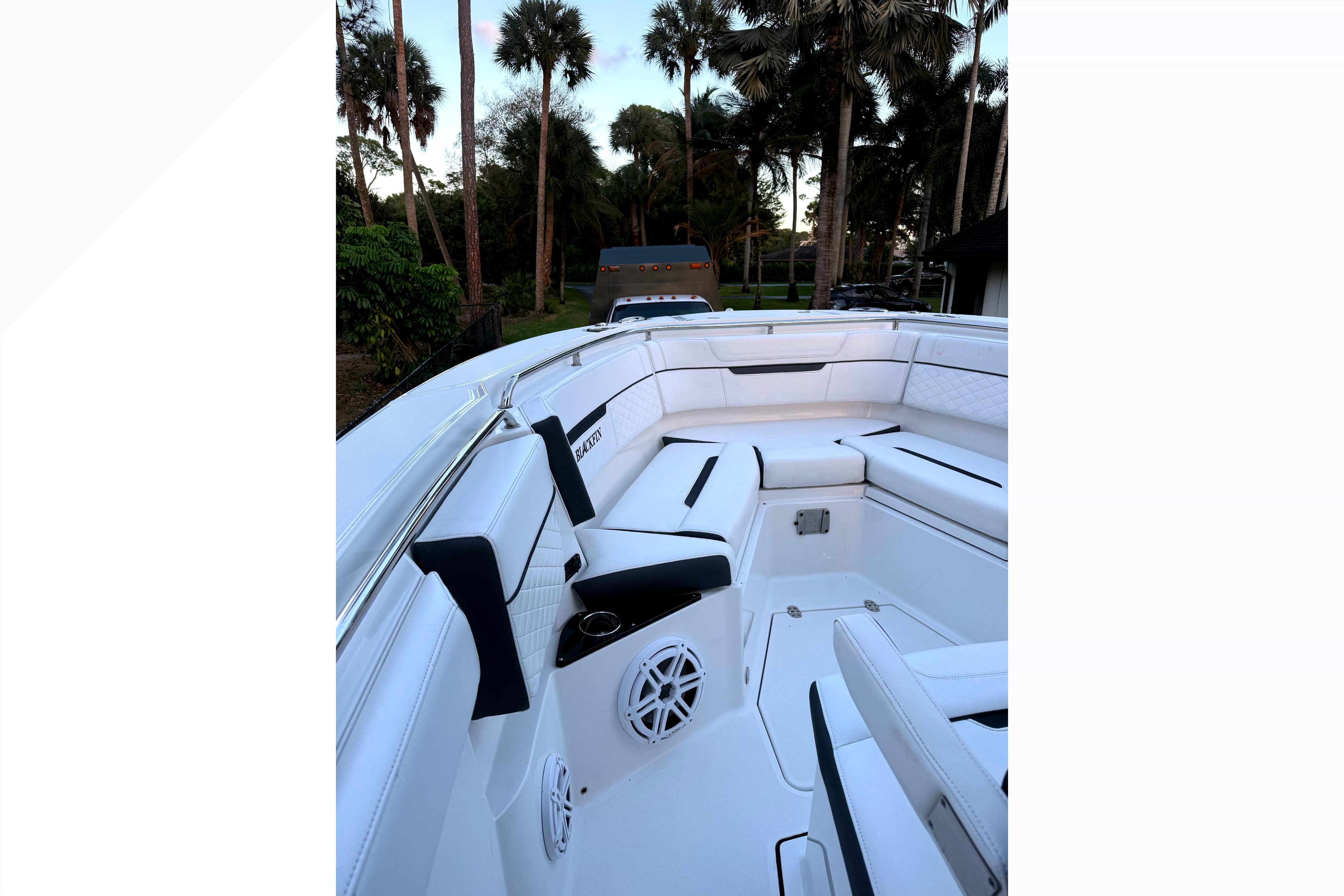 2021 Blackfin 272 CC boat interior with white seating and palm trees in the background.