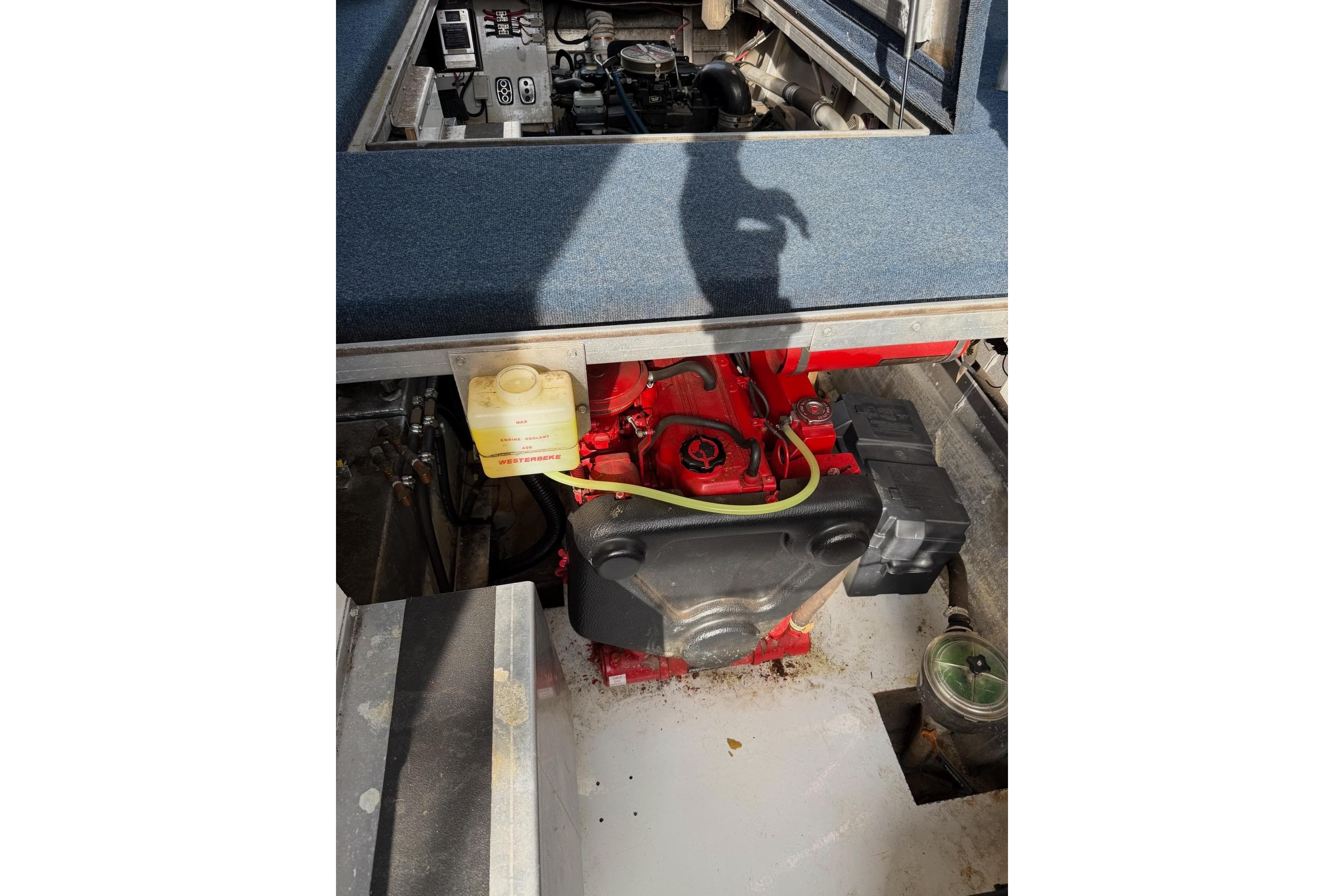 Engine compartment of a 2000 Sunstar 16x65 houseboat, featuring a red engine and components.