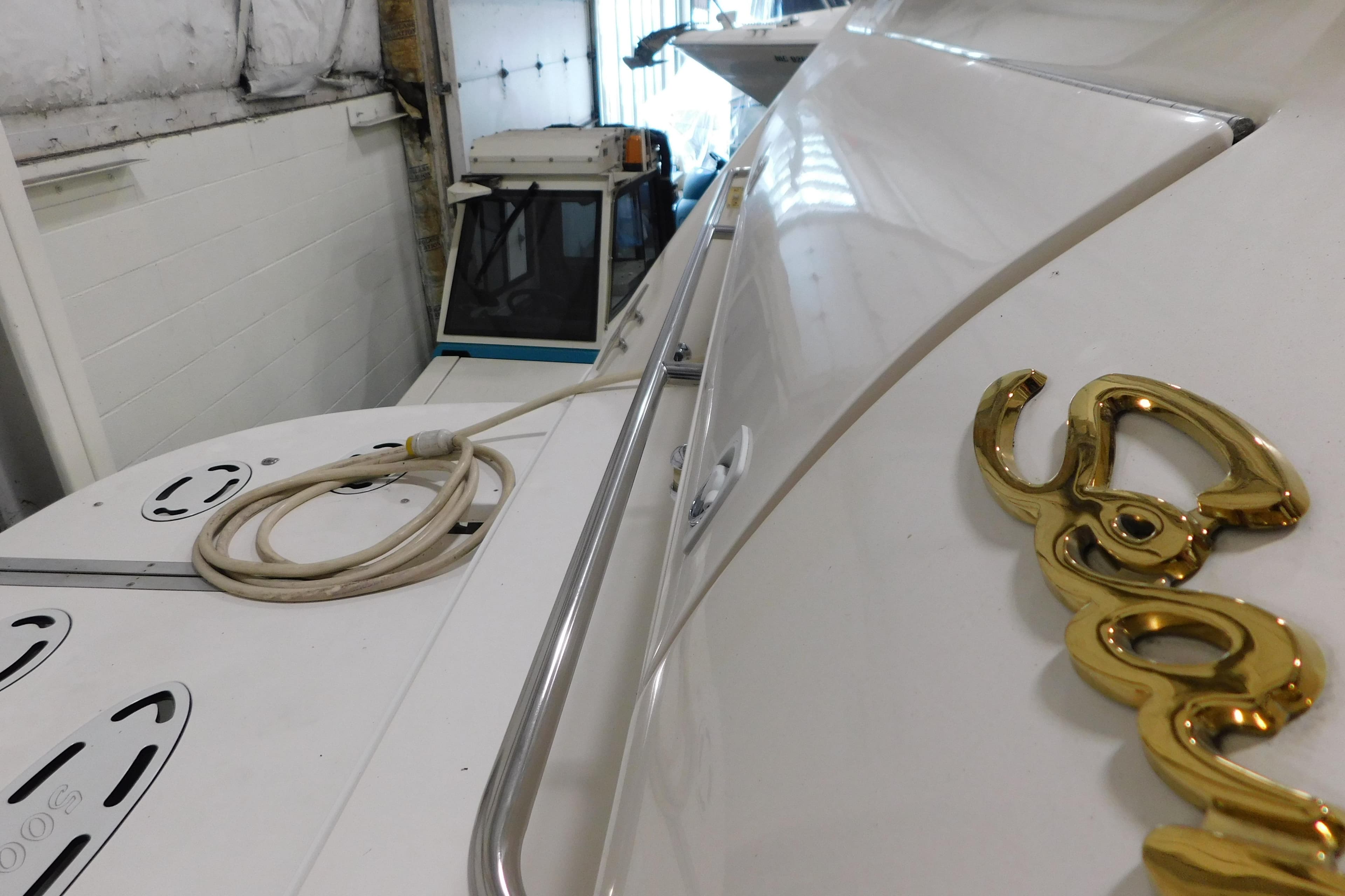 1999 Sea Ray 500 Sundancer yacht in storage, showcasing sleek design and gold emblem.