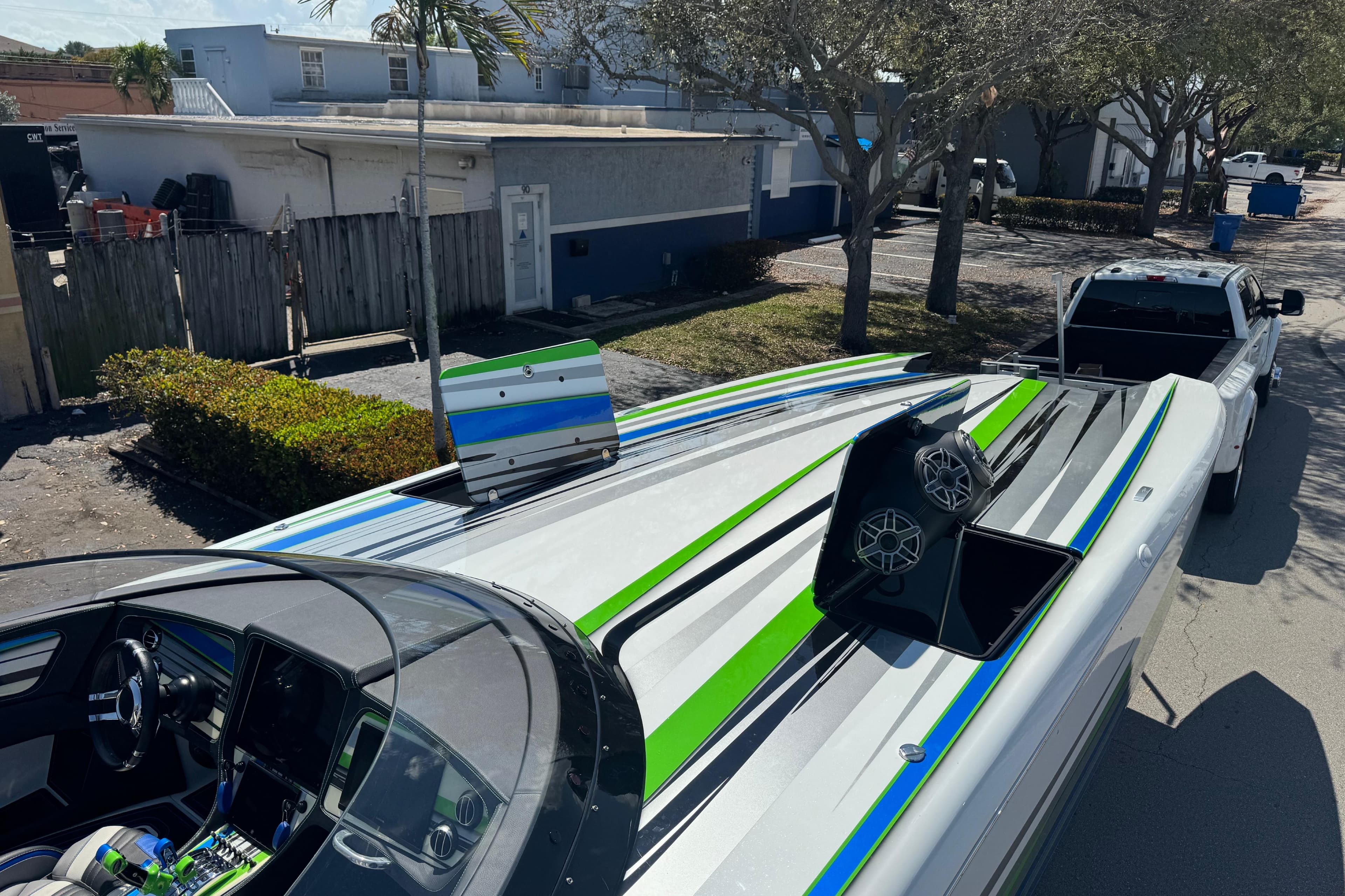 2022 MTI 390X powerboat with vibrant green and blue accents, parked on a street.