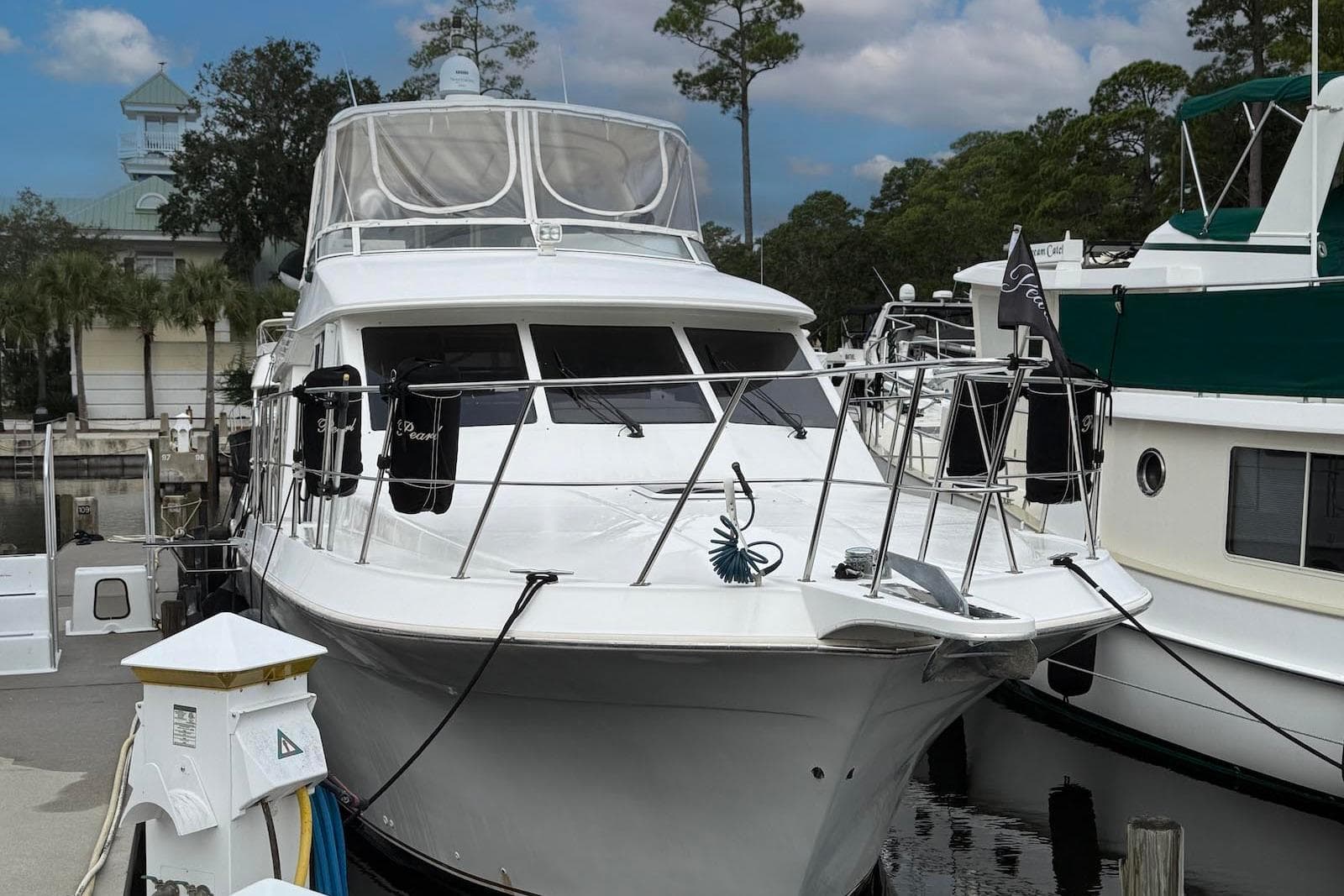 2004 Navigator 4800 yacht docked at marina, surrounded by trees and buildings.