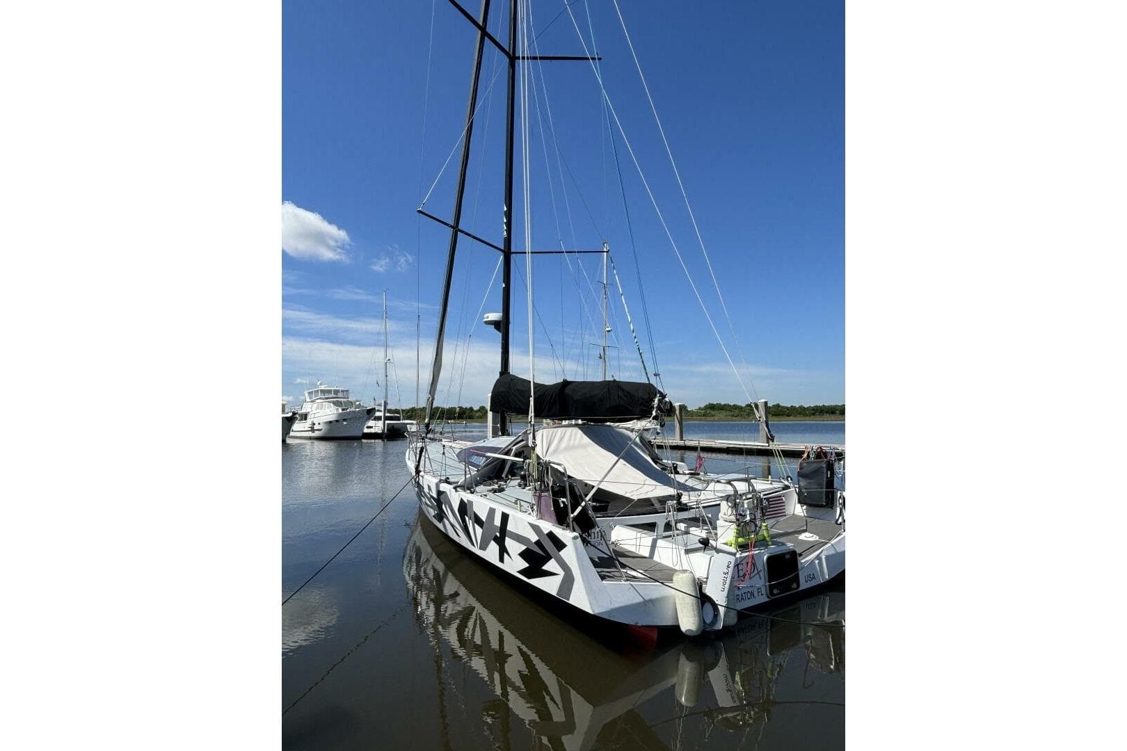 Sailboat Akilaria RC2 Class 40, 2009 model, docked in a marina under clear blue skies.