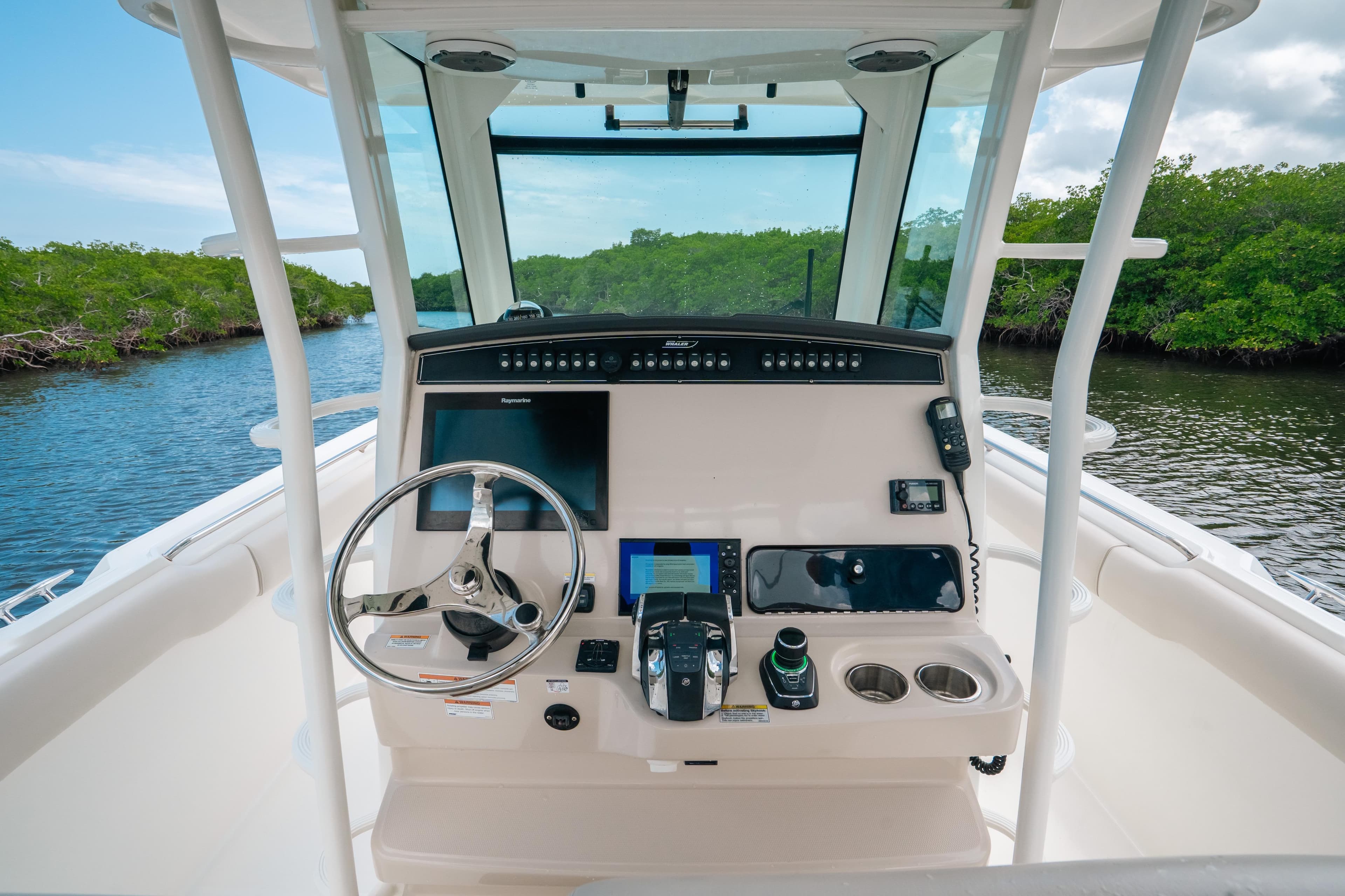 2019 Boston Whaler 330 Outrage helm with modern controls and scenic waterway view.