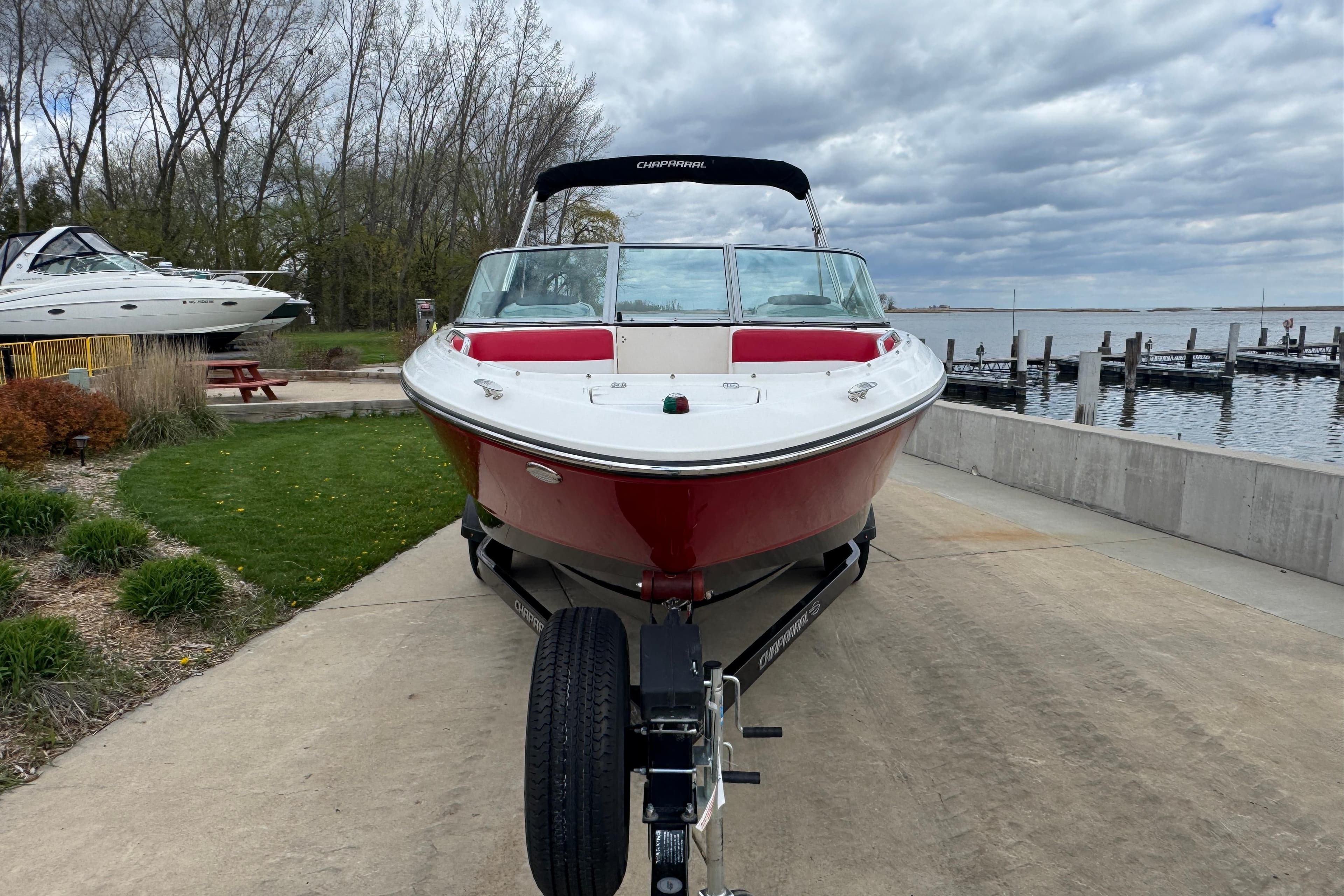 2017 Chaparral 21 H2O Sport boat on trailer by lakeside dock.