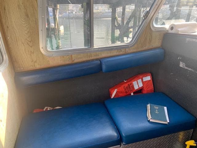 Interior of 1994 EagleCraft Workboat with blue seating, life jacket, and a book.