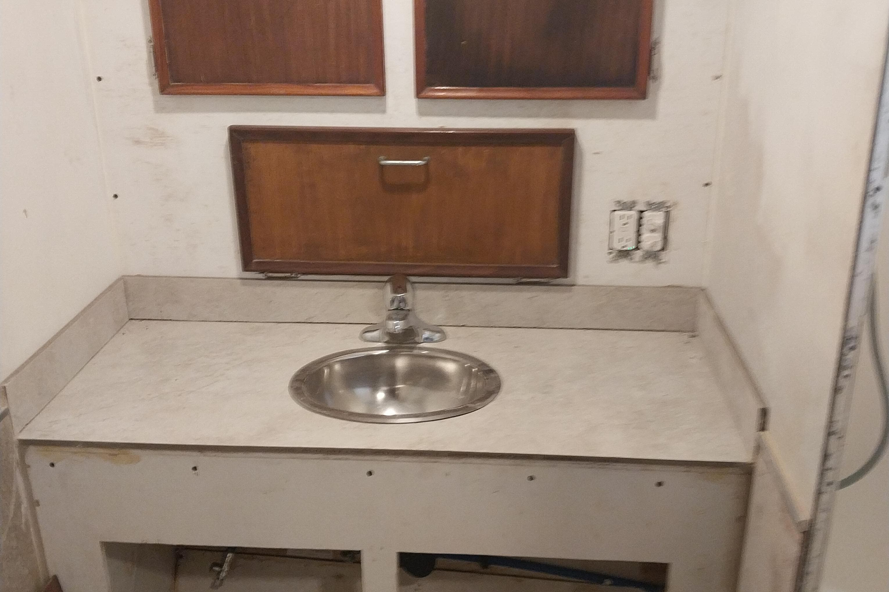 1982 Hatteras 61 Motor Yacht bathroom sink with wooden cabinets and countertop.