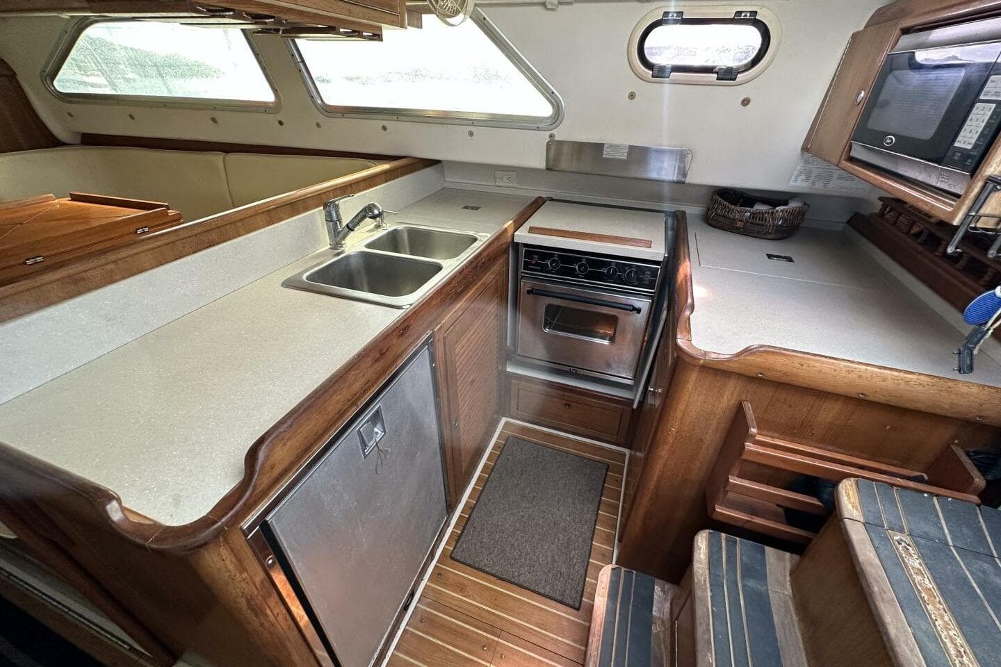 2008 Catalina Morgan 440 yacht interior kitchen with wood finish, dual sink, and stove.
