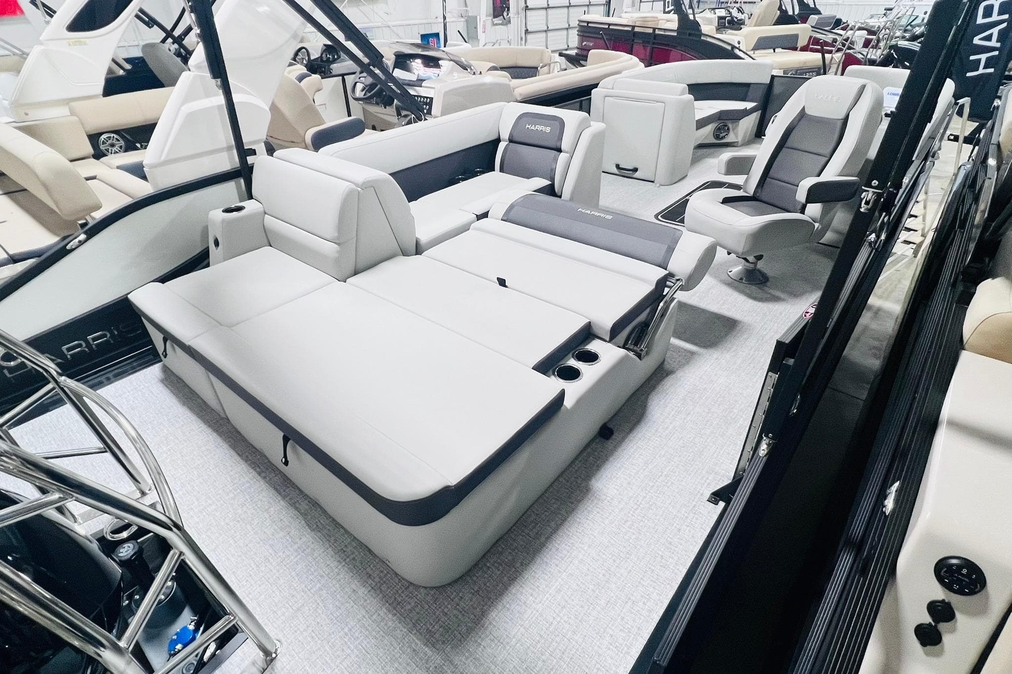 2025 Harris Cruiser 230 interior with luxurious seating and modern design in a showroom.