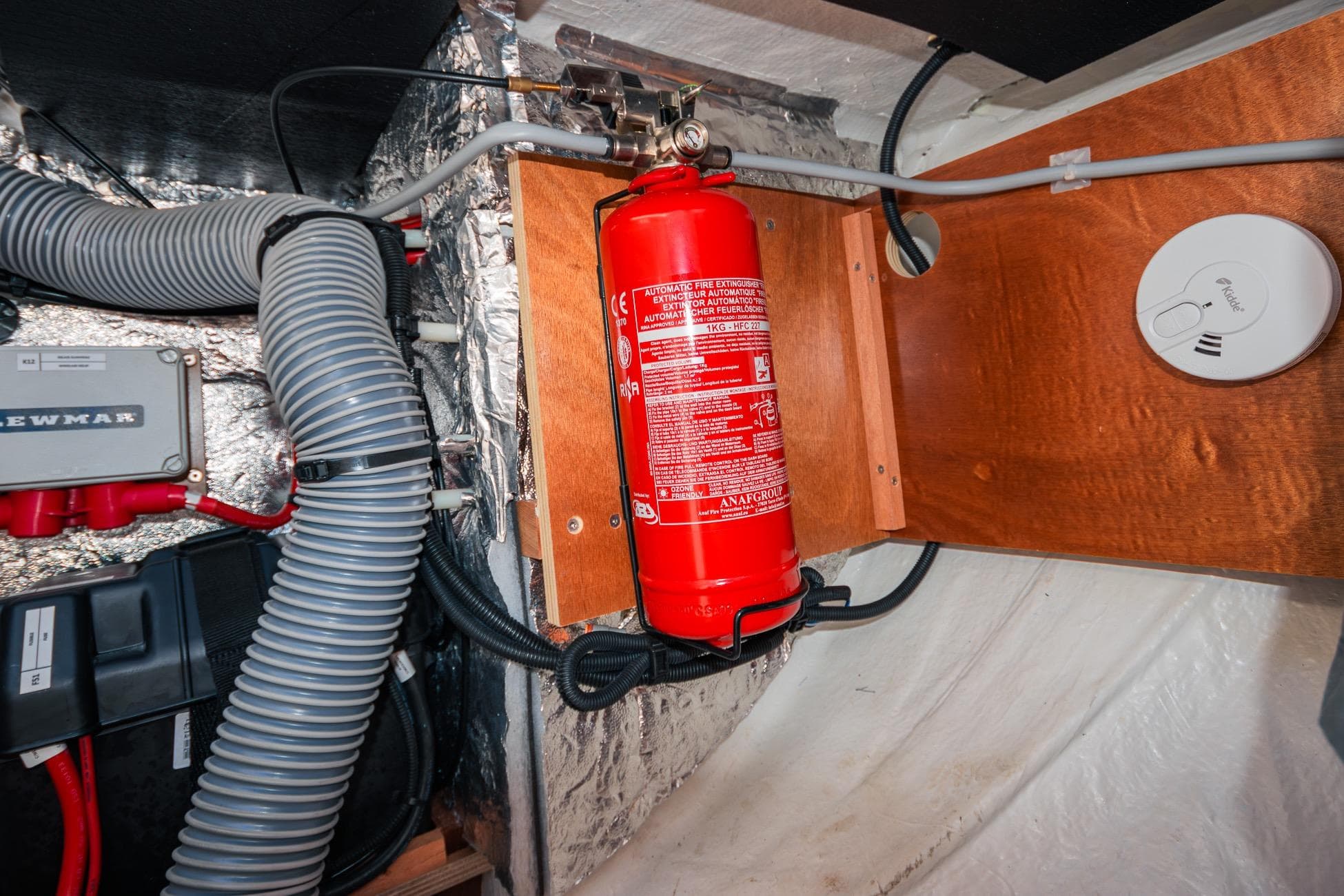 Engine room of 2024 Lagoon 51 yacht with fire extinguisher and safety equipment.