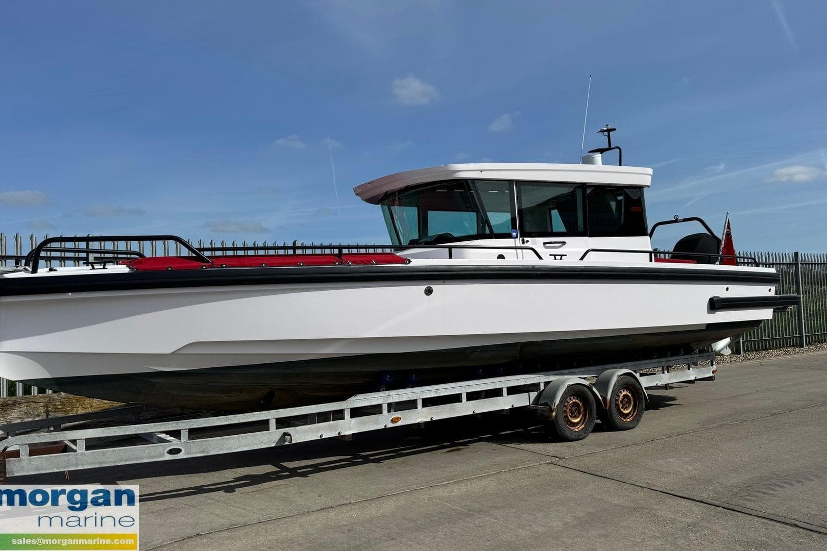 2021 Axopar 28 Cabin boat on trailer, displayed outdoors under clear sky.