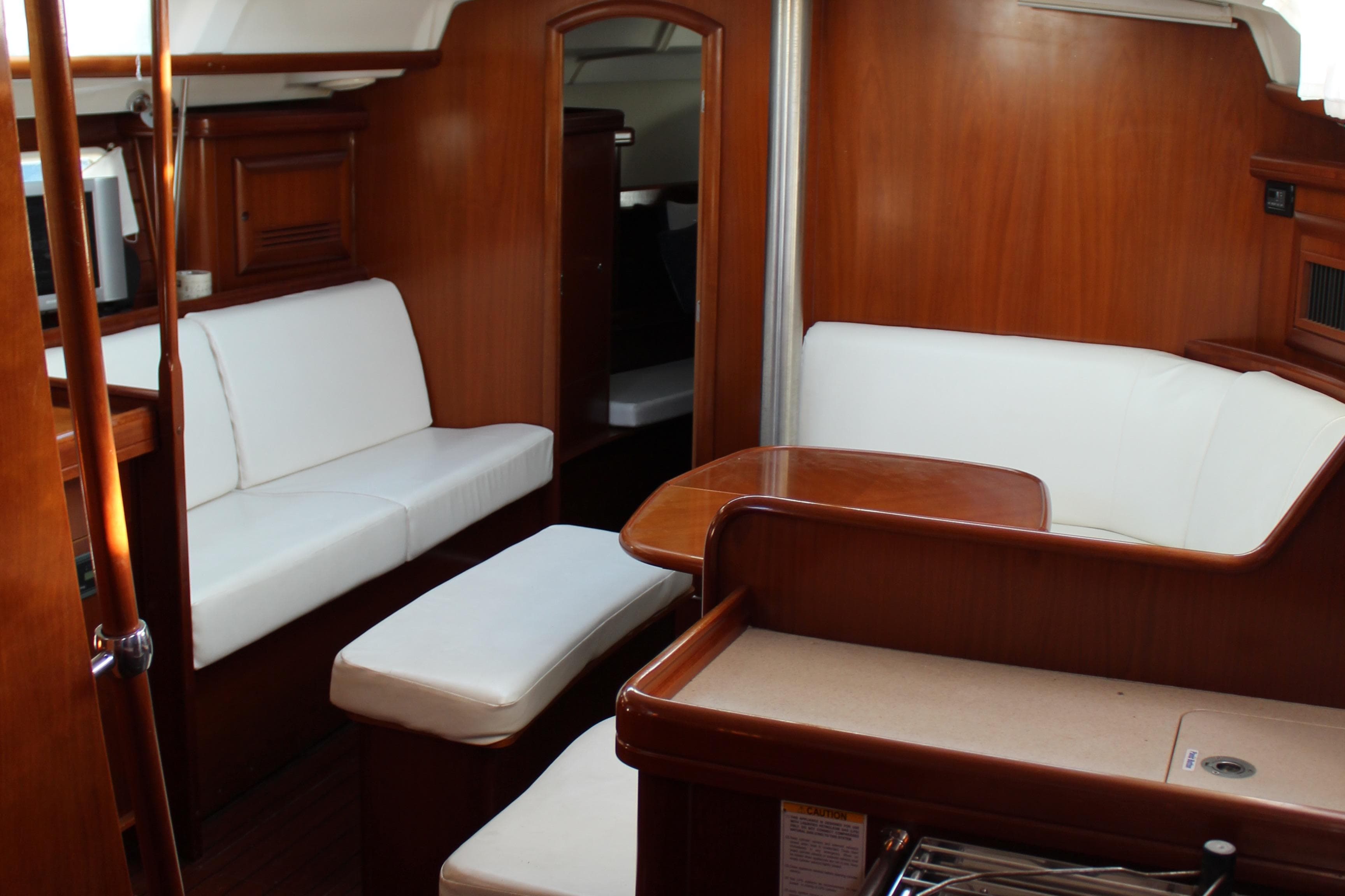 Interior of 2004 Beneteau Oceanis Clipper 423 yacht with white seating and wooden finishes.