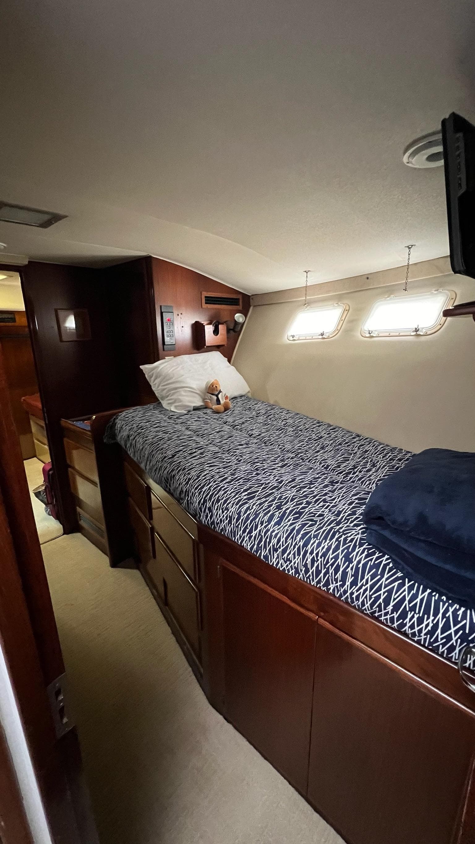 1987 Hatteras Motoryacht cabin with single bed, wooden cabinetry, and porthole windows.