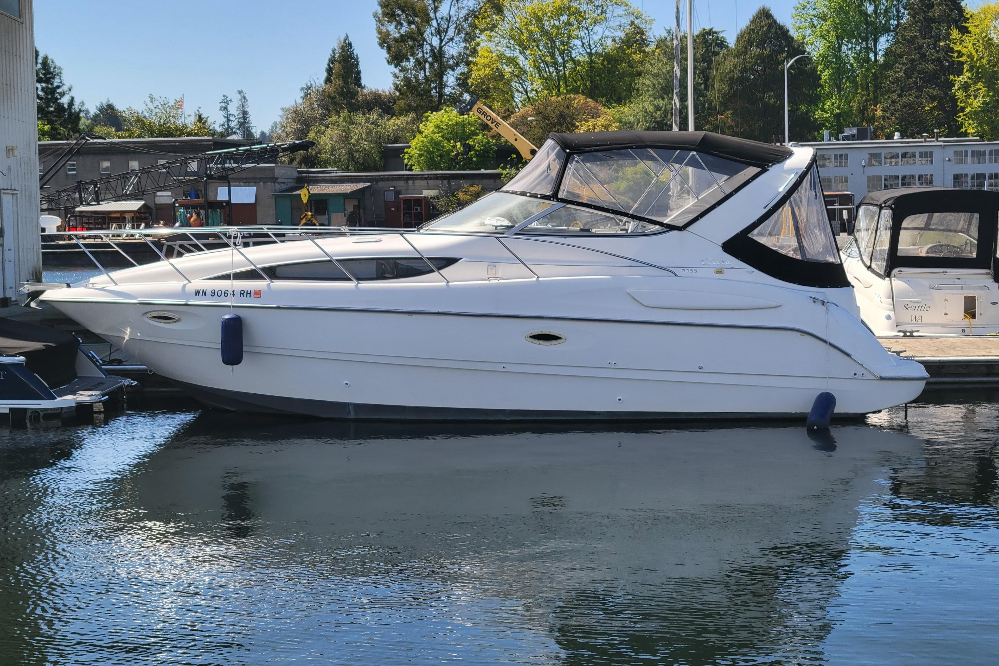 1999 Bayliner 3055 Ciera Sunbridge boat docked in a marina, side view.