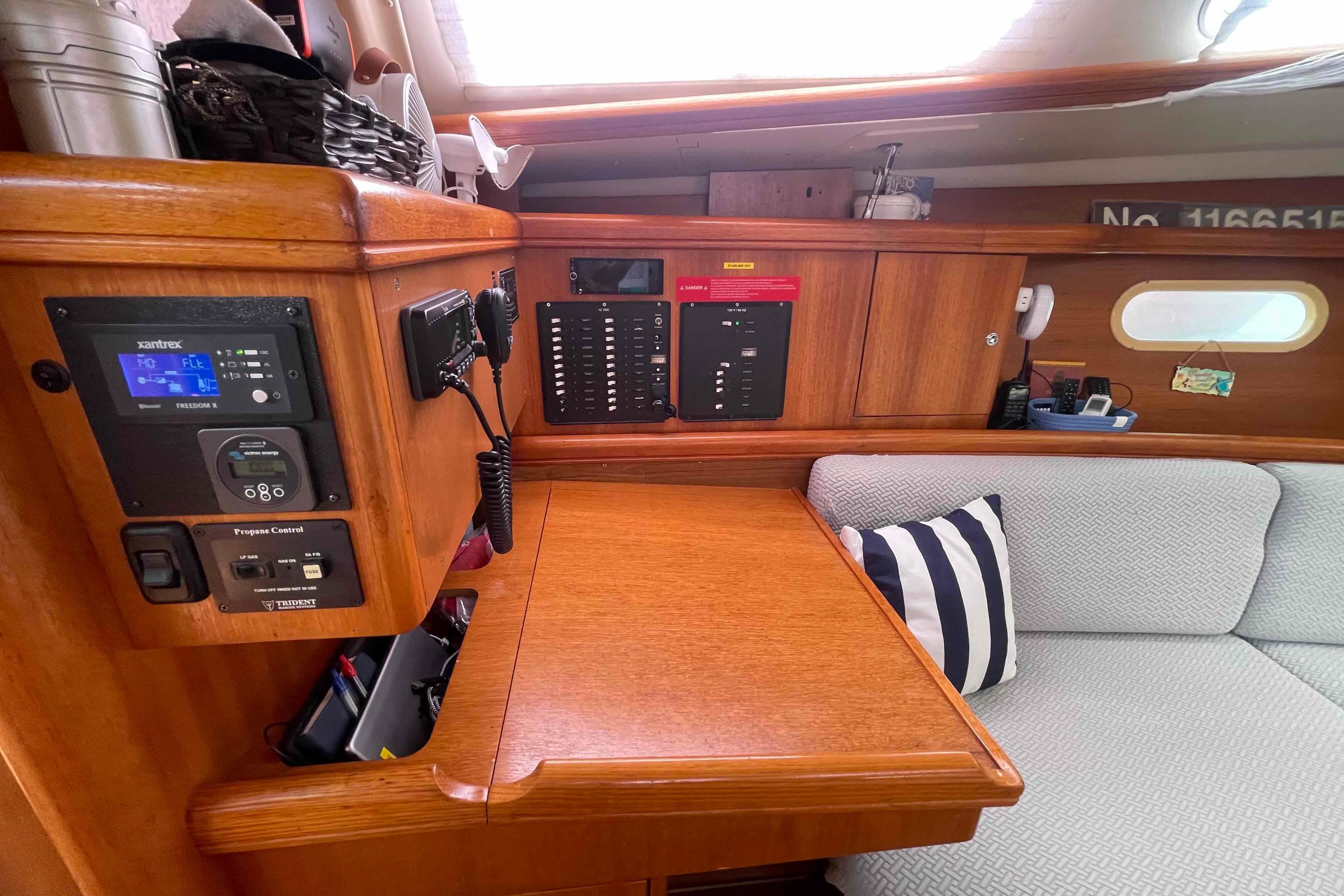 Interior of a 2004 Hunter 36 sailboat featuring navigation controls and cozy seating area.