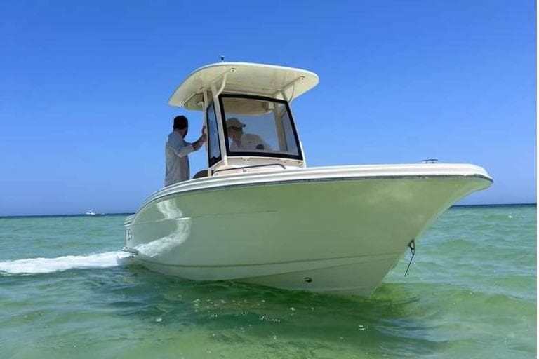2025 Scout 215 XSF boat cruising on clear blue water under a sunny sky.