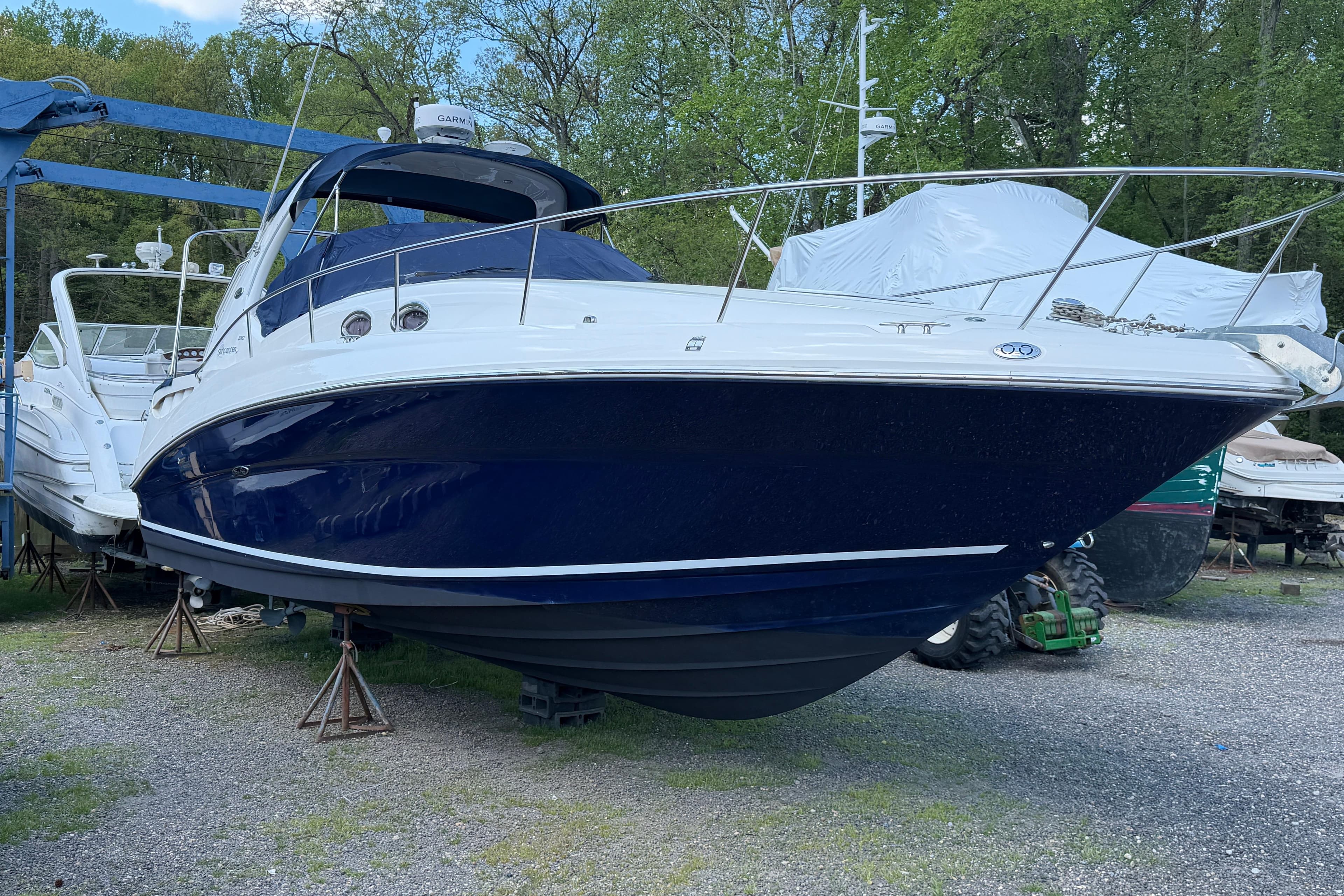 2005 Sea Ray Sundancer 320 boat on stands, surrounded by trees and other boats.