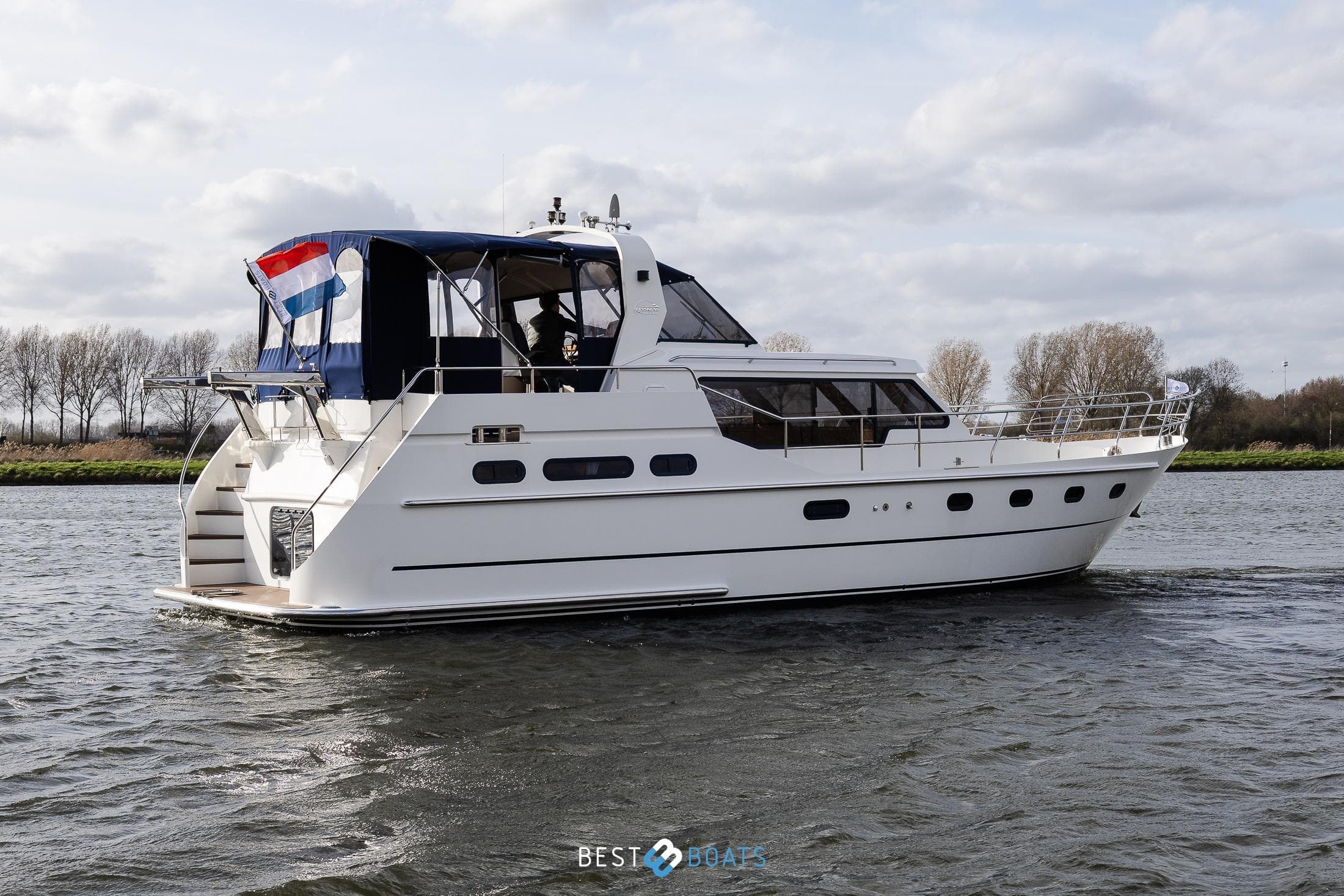 2008 Linskens Catfish 1400 yacht cruising on a calm river under cloudy skies.