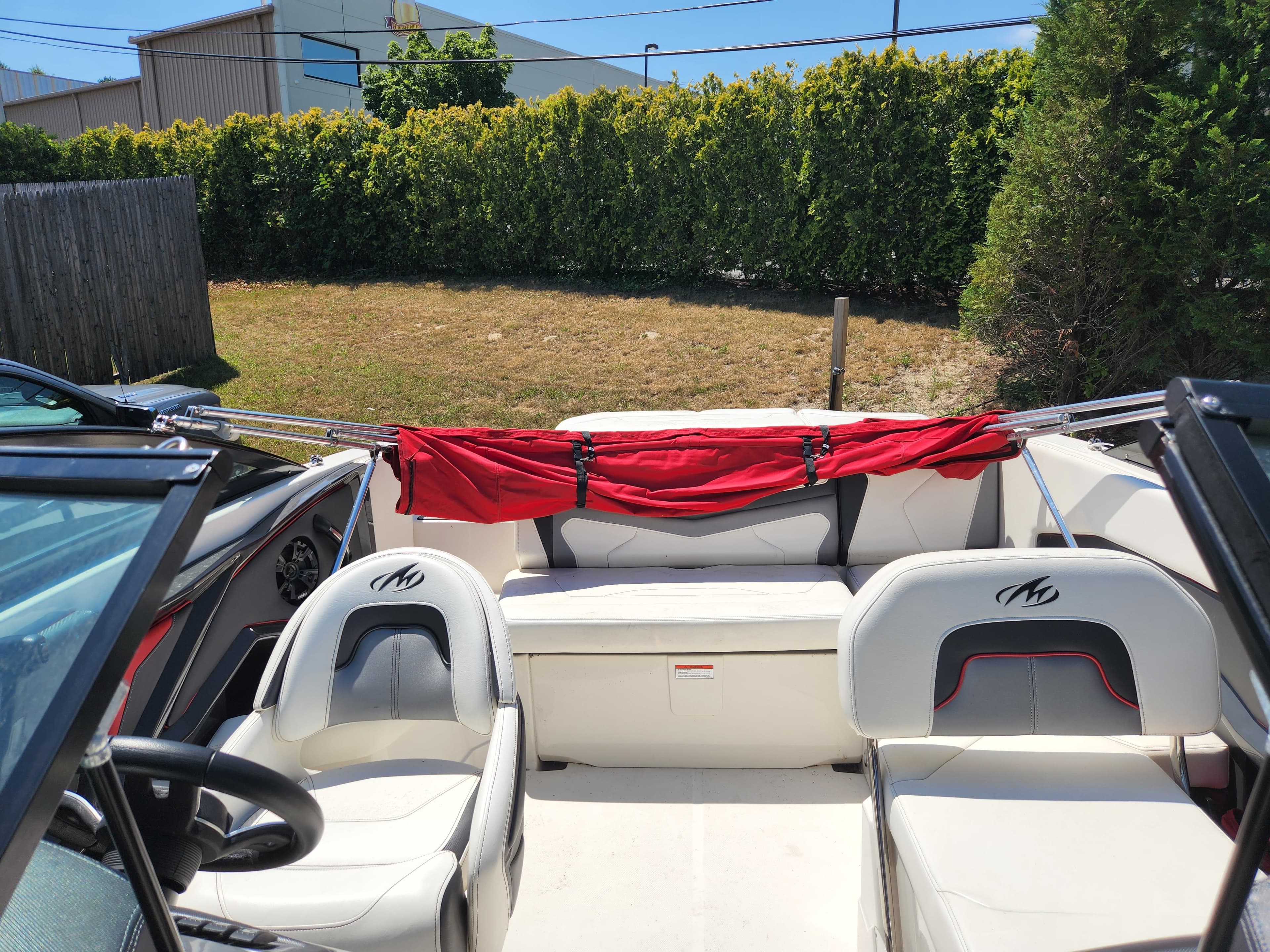 2014 Monterey 234 SS boat interior with white seating and red cover.
