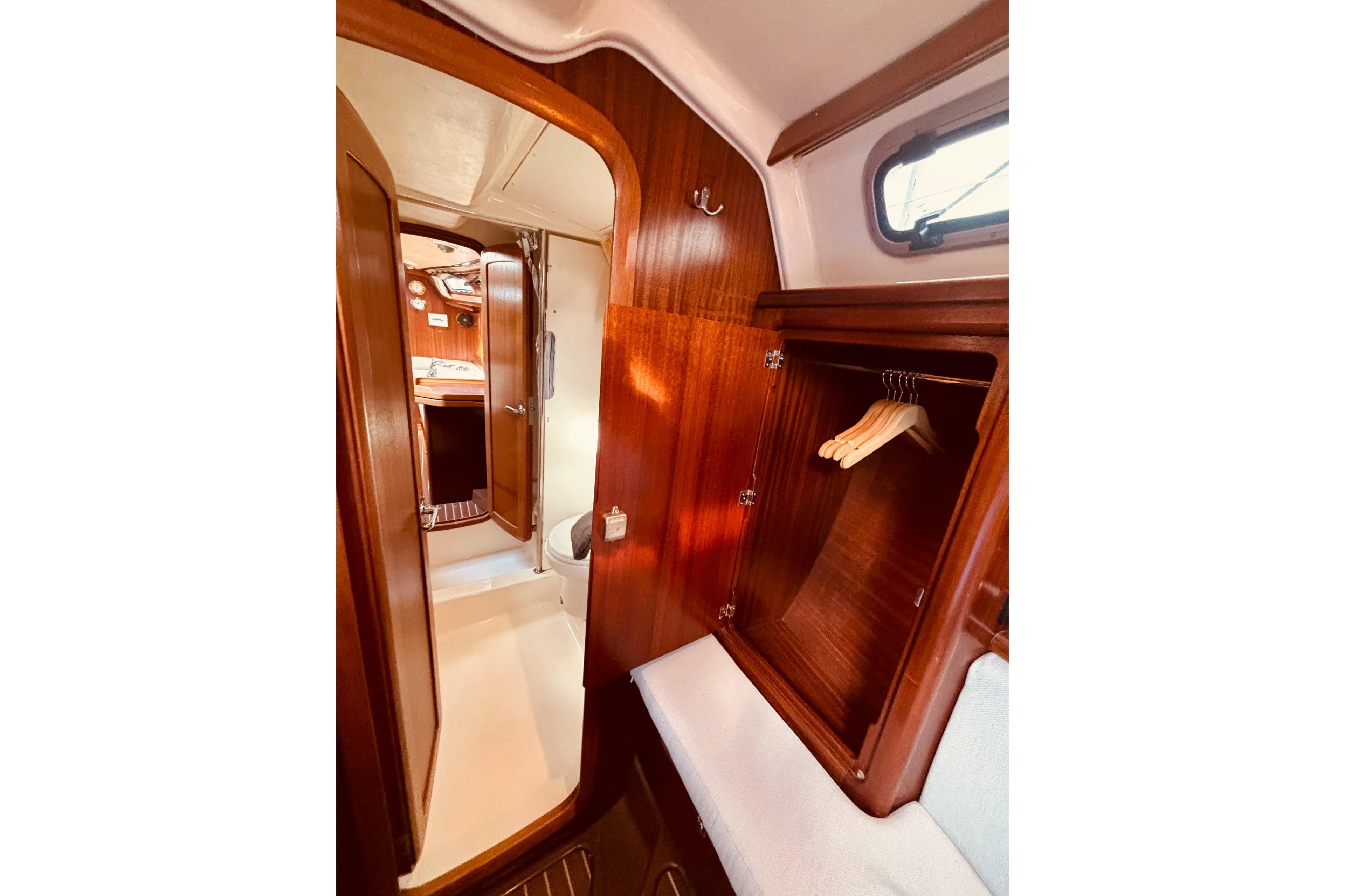 Interior of 1999 Bavaria 38 Ocean yacht with wooden cabinetry and closet space.