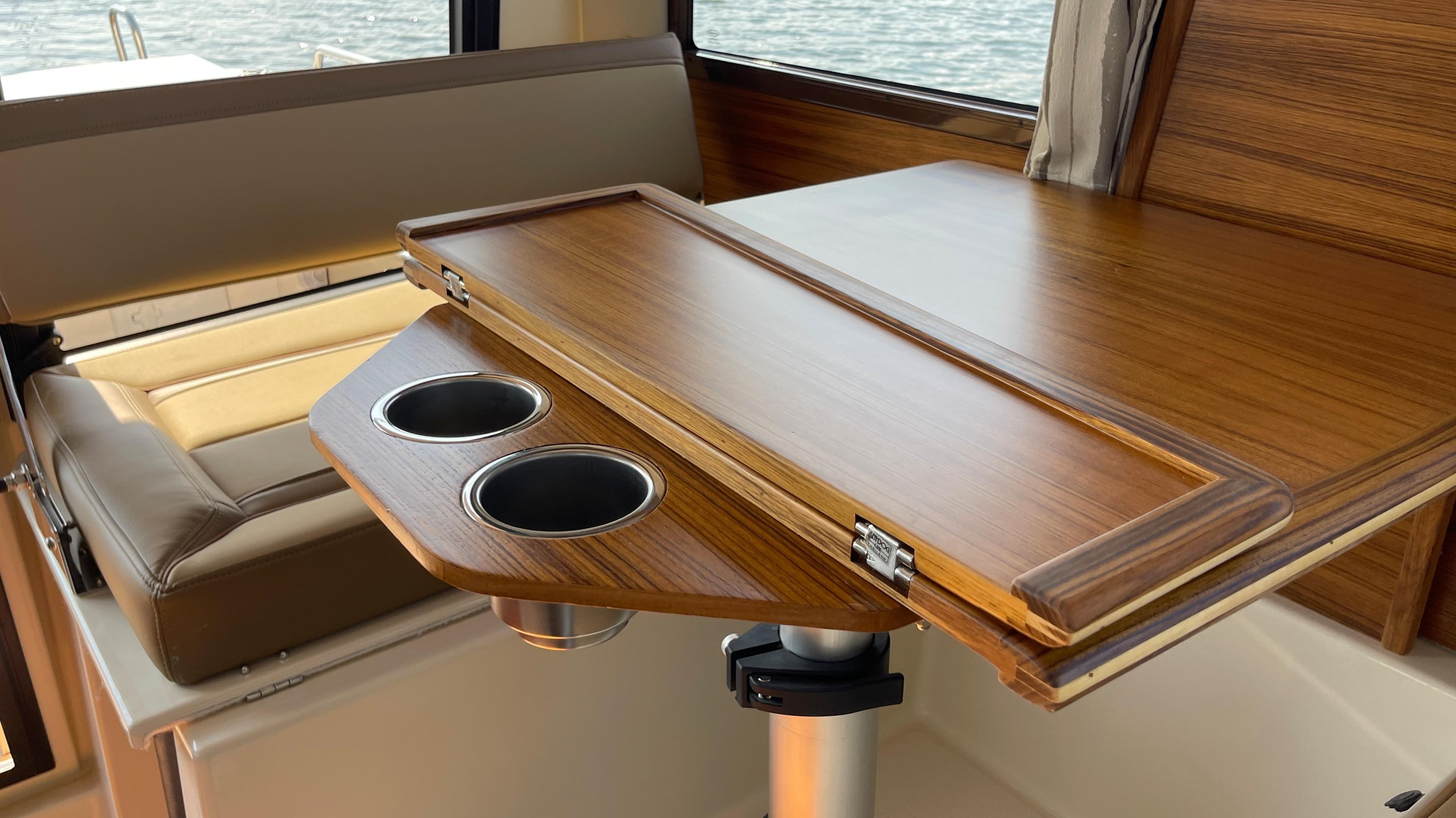 Interior of 2025 Ranger Tugs R-25 with wooden table and cup holders.