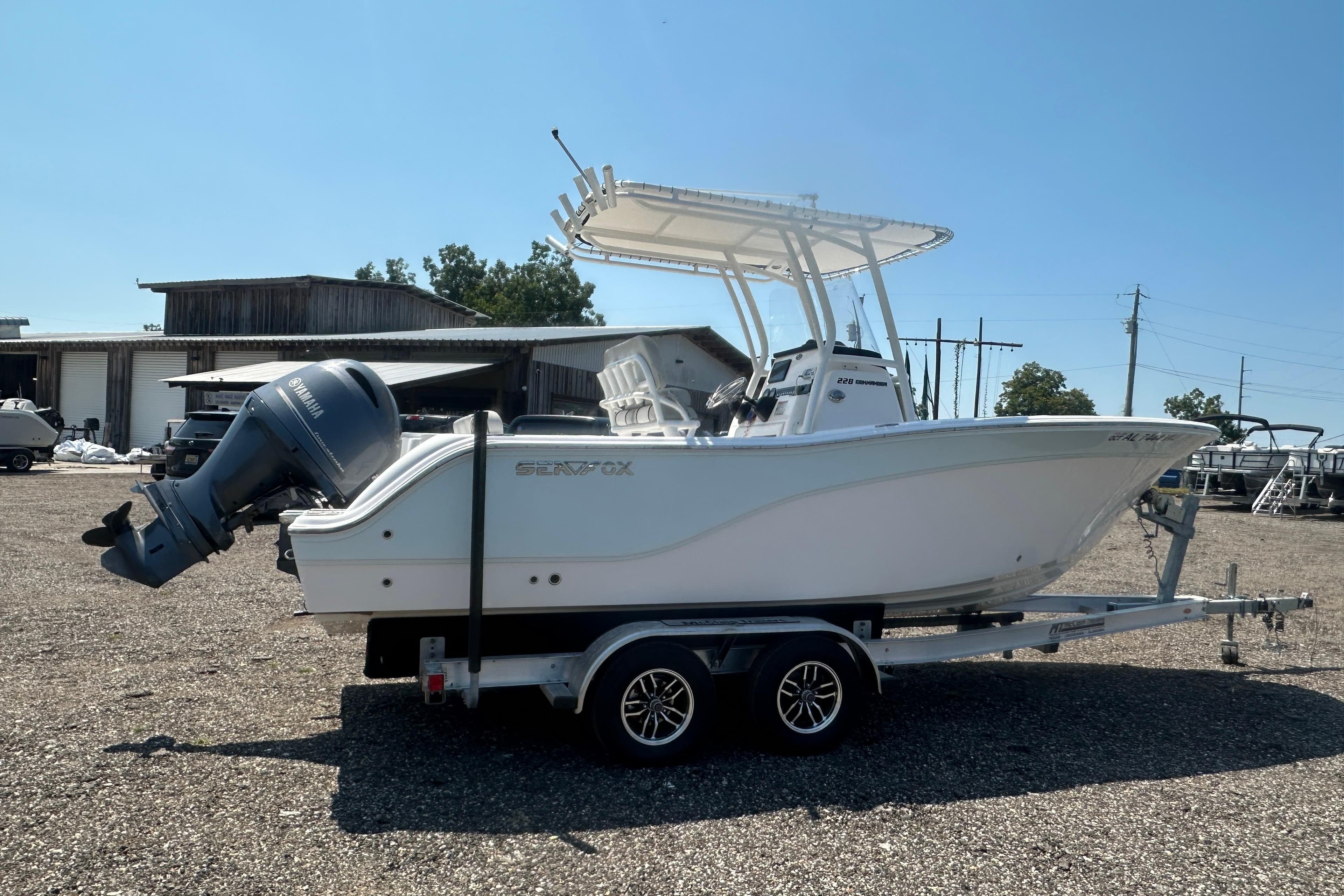 2023 Sea Fox 228 Commander boat on trailer, parked outdoors under clear sky.