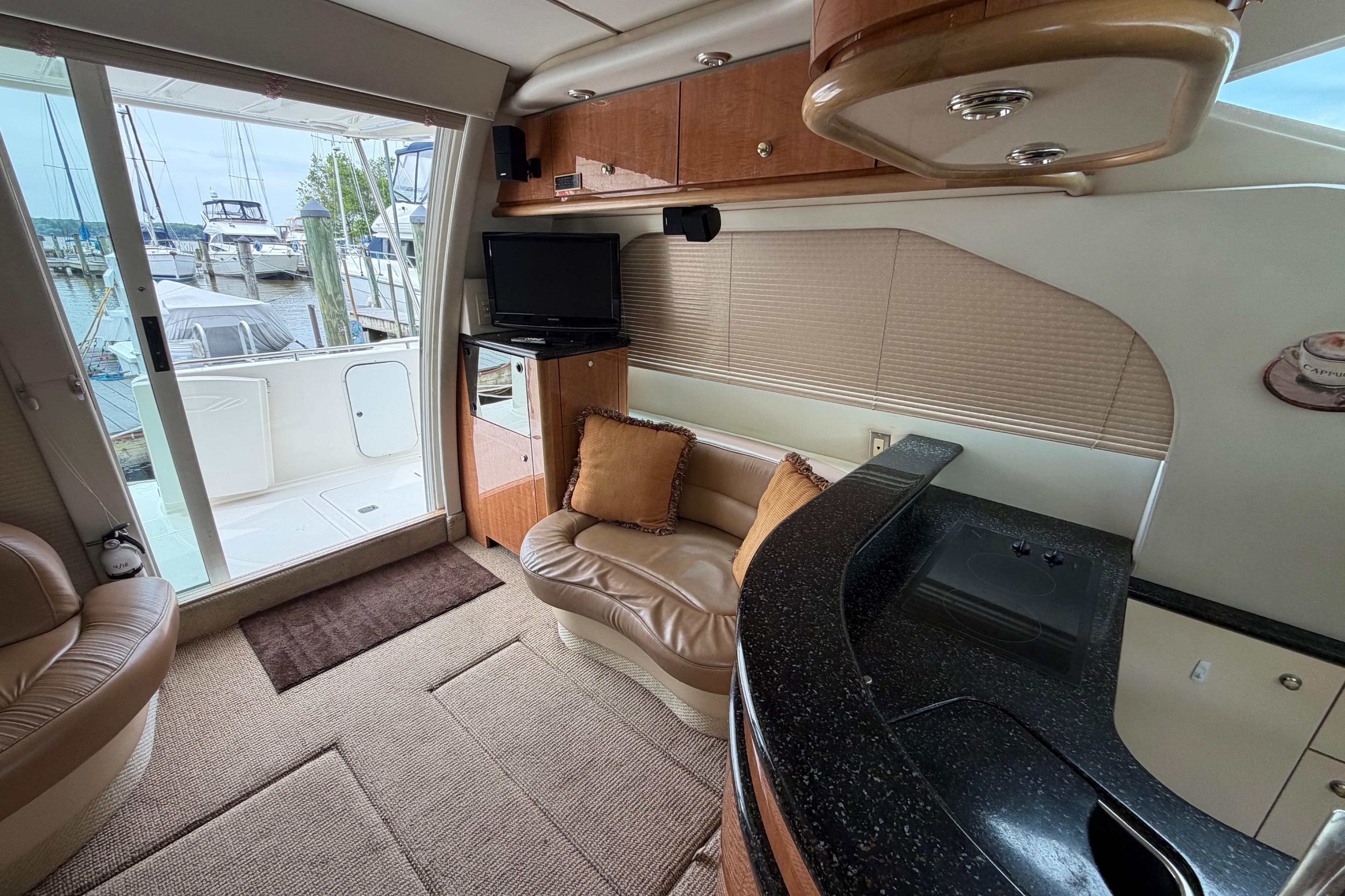 Interior of 2001 Maxum 4600 SCB yacht with seating, TV, and kitchenette.