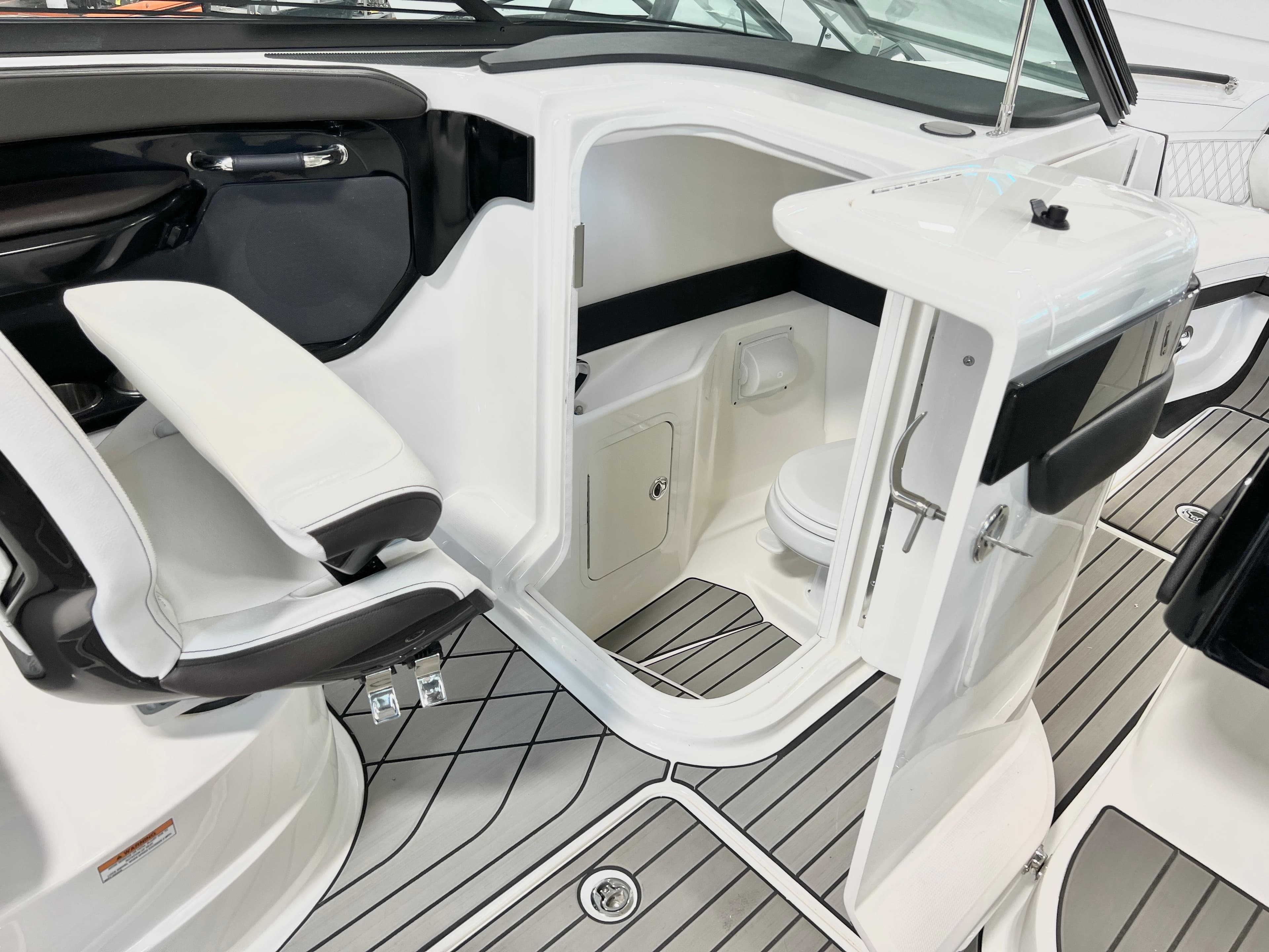 2024 Sea Ray SLX 260 boat interior with seating and compact restroom.