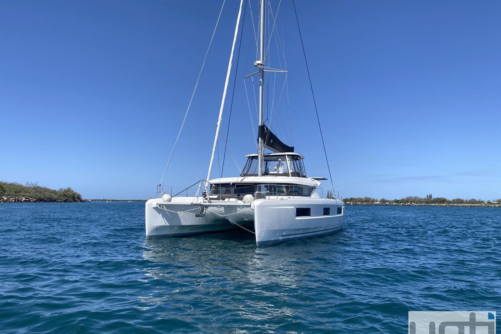 2022 Lagoon 46 catamaran sailing on clear blue waters under a sunny sky.