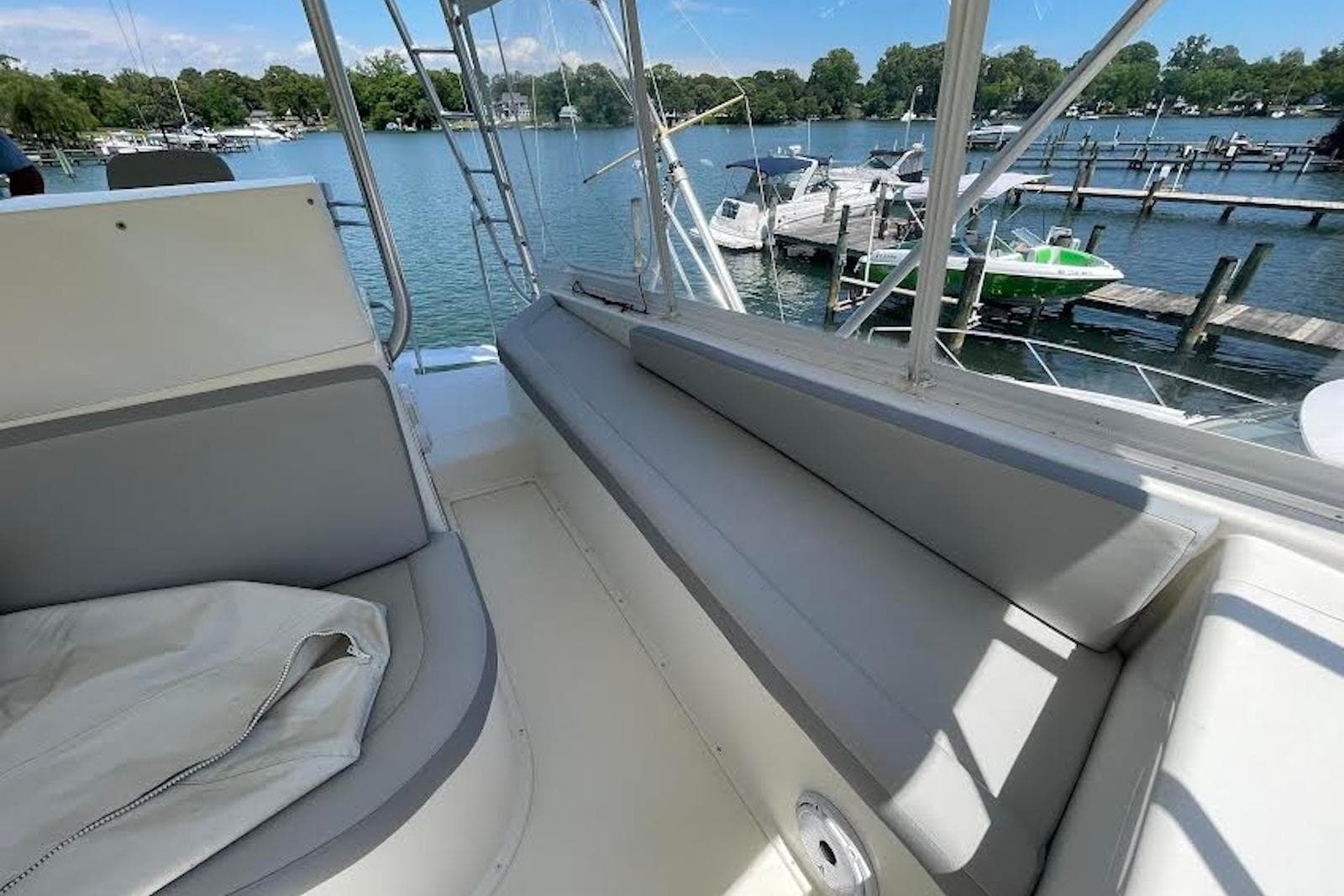 1990 Viking 53 Convertible yacht interior with seating, overlooking marina and docked boats.