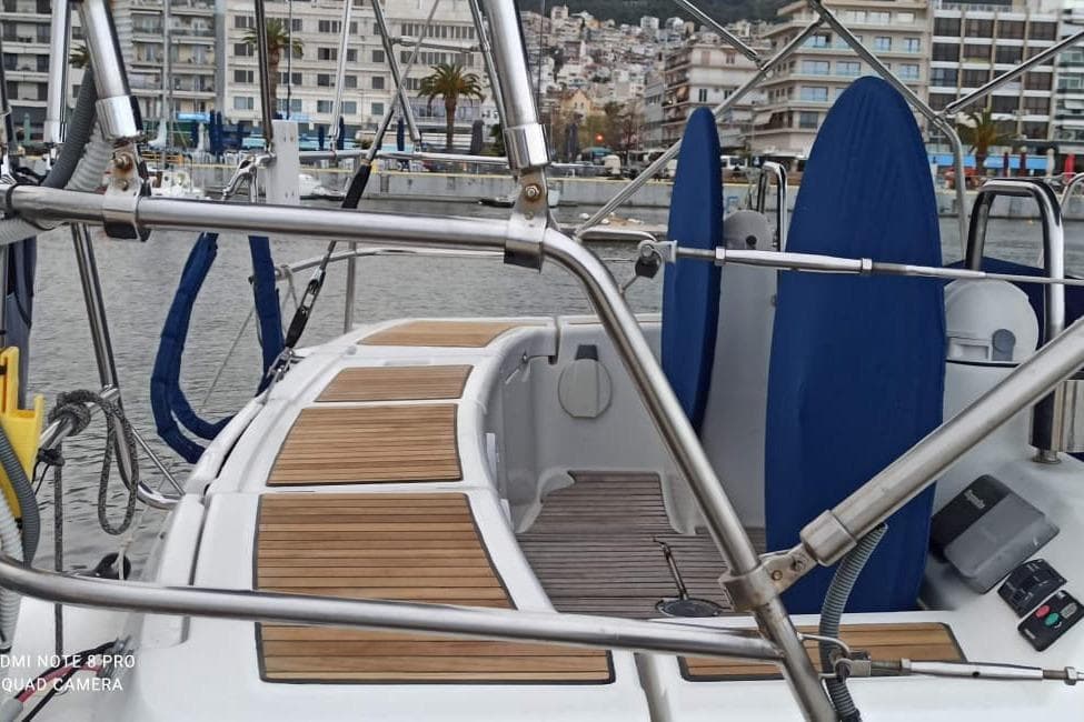 2009 Beneteau Oceanis 46 yacht docked in a marina, featuring teak deck and urban backdrop.