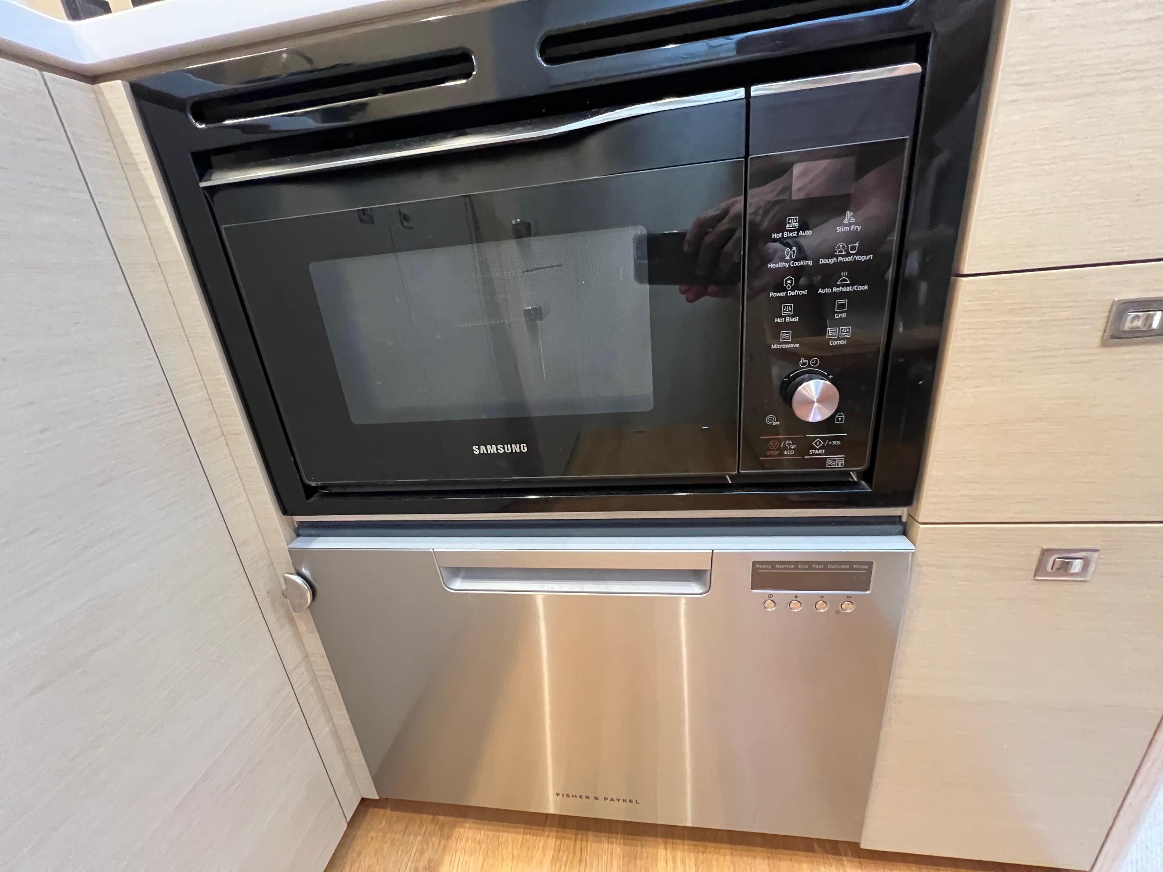 Built-in Samsung microwave and Fisher & Paykel dishwasher in a 2019 Princess V50 yacht kitchen.