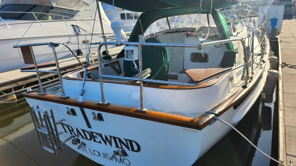 1989 Cabo Rico 34 sailboat docked, featuring wooden accents and "TRADEWIND" name on the stern.