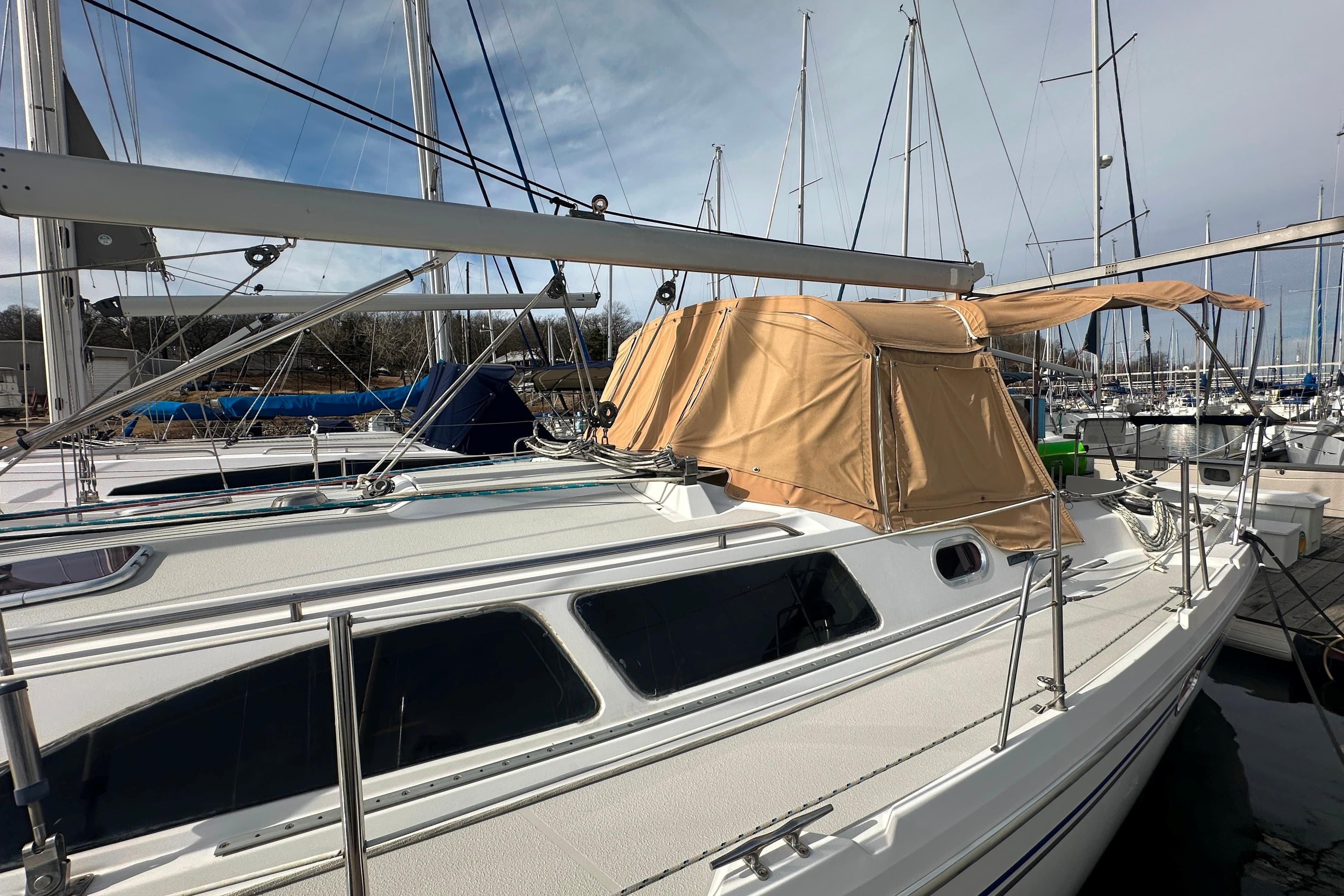 2006 Catalina 387 sailboat docked at marina with tan canopy.